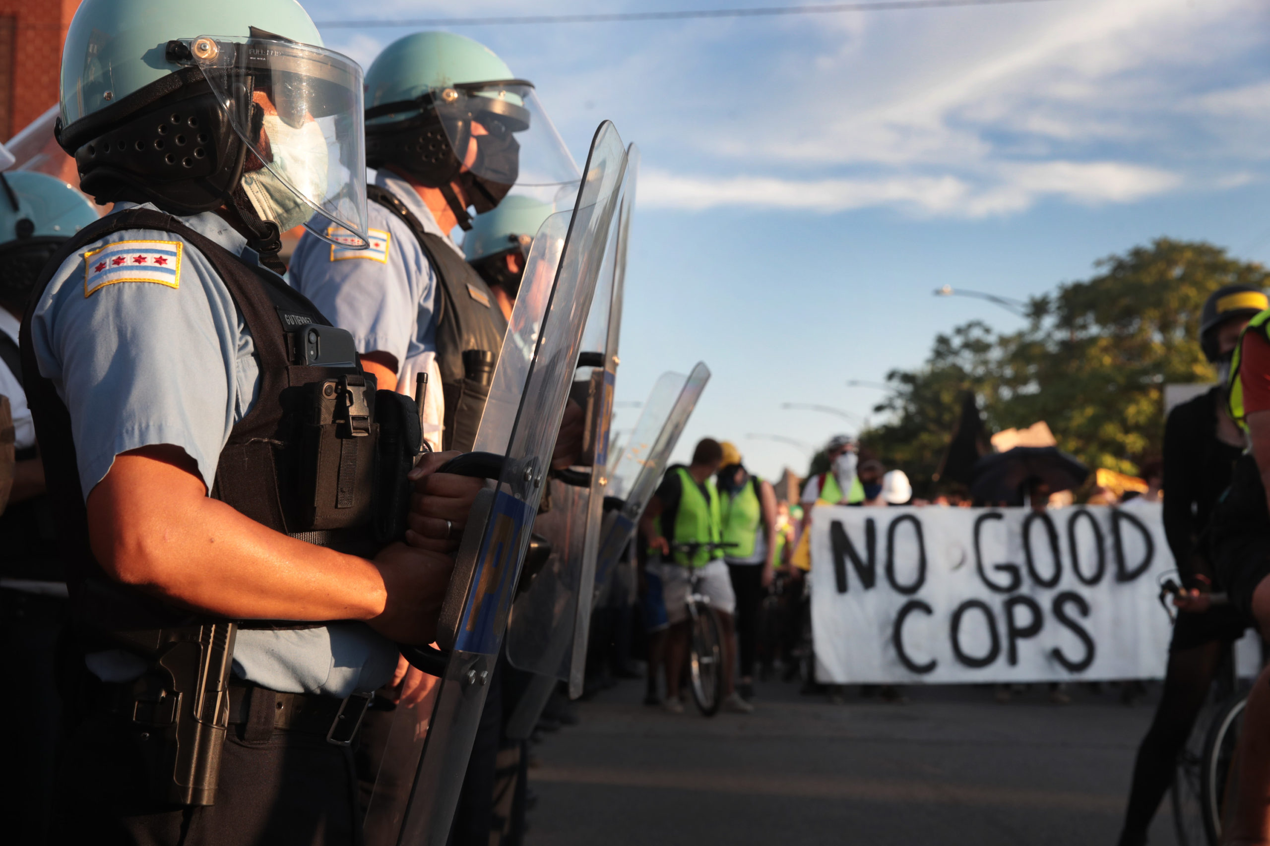 Police stand guard at the Homan Square police station while activists hold a rally calling for the defunding of police on July 24, 2020 in Chicago, Illinois. The annual budget for the Chicago Police Department is more than $1.6 billion. (Photo by Scott Olson/Getty Images)