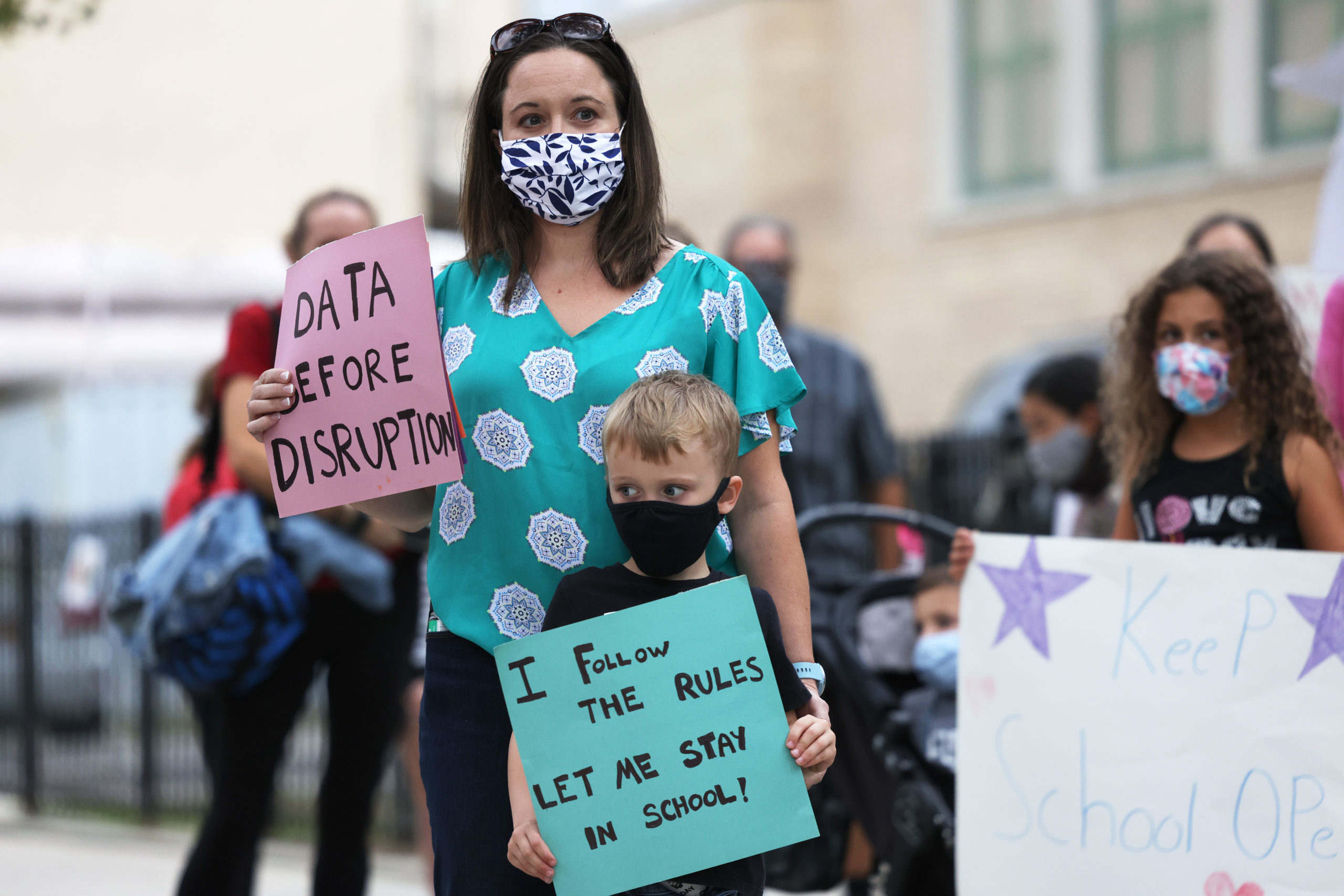 Parents and kids hold signs during a protest in favor of reopening schools in New York City. (Michael M. Santiago/Getty Images)