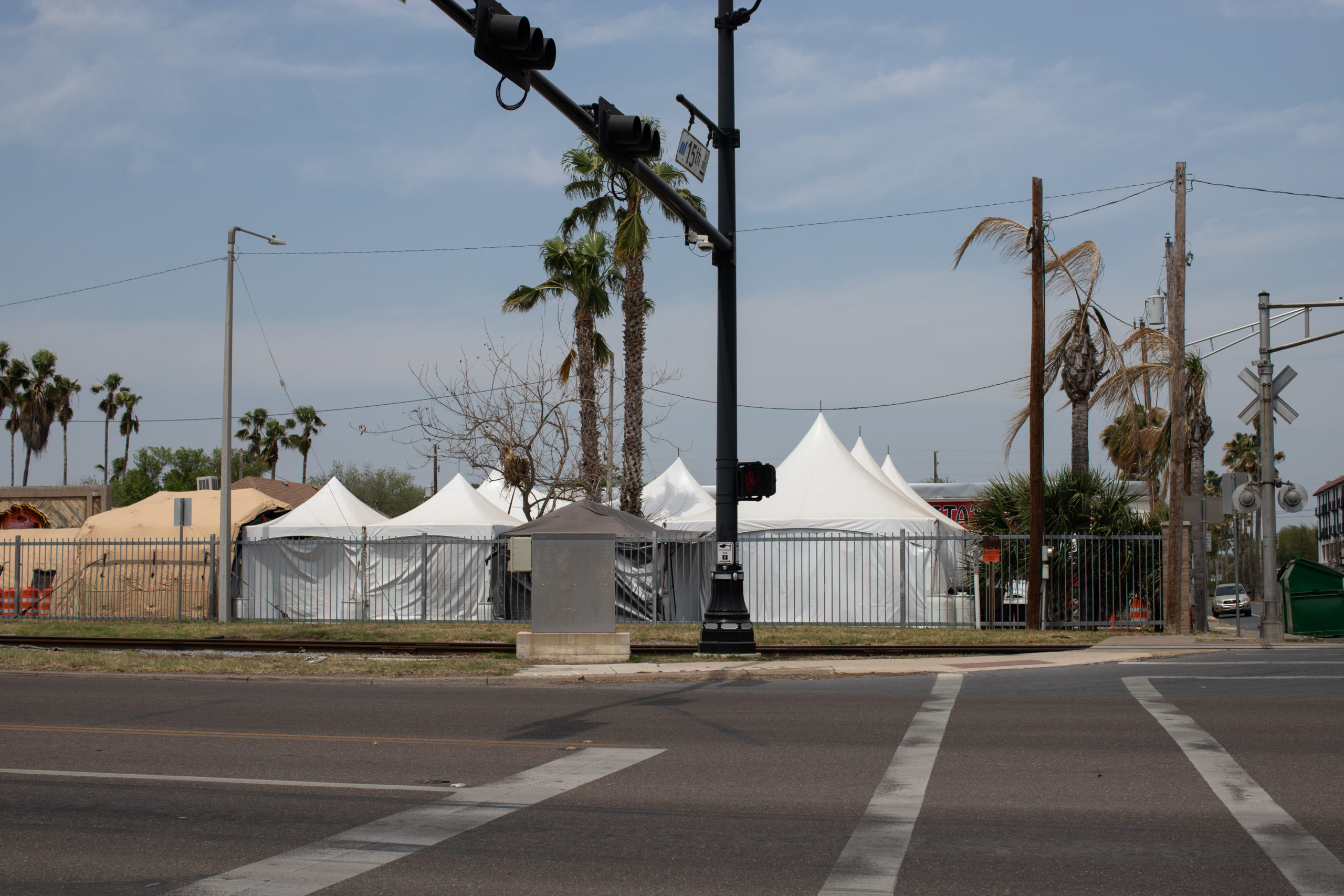 A temporary COVID-19 testing facility composed of several tents guarded by a private security official and a Customs and Border Protection officer was set up across the street from the bus station in McAllen, Texas on March 27, 2021. (Kaylee Greenlee - Daily Caller News Foundation) 