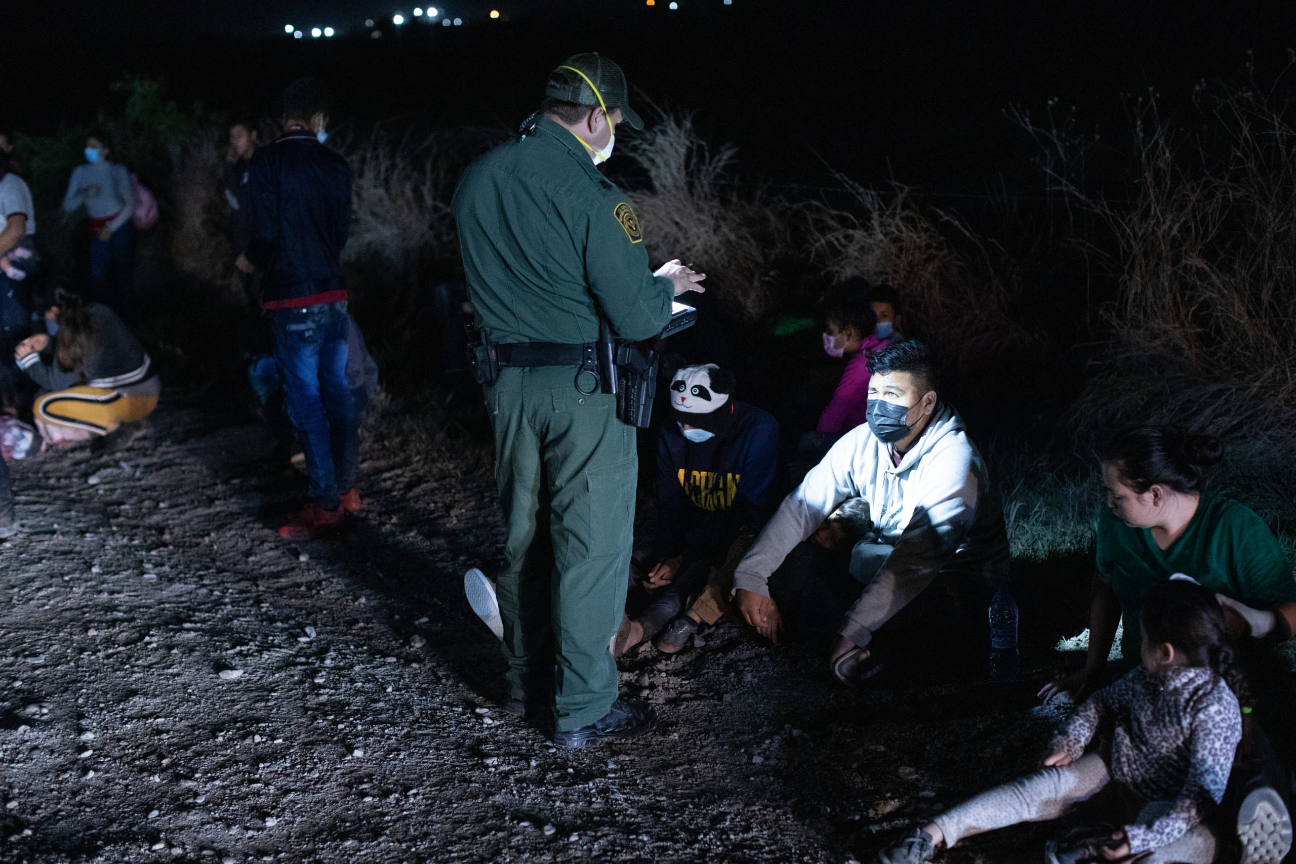 Several illegal migrants waited on the grass near the side of a public road as Customs and Border Protection officials worked to process the groups in La Joya, Texas on March 27, 2021. (Kaylee Greenlee - Daily Caller News Foundation) 