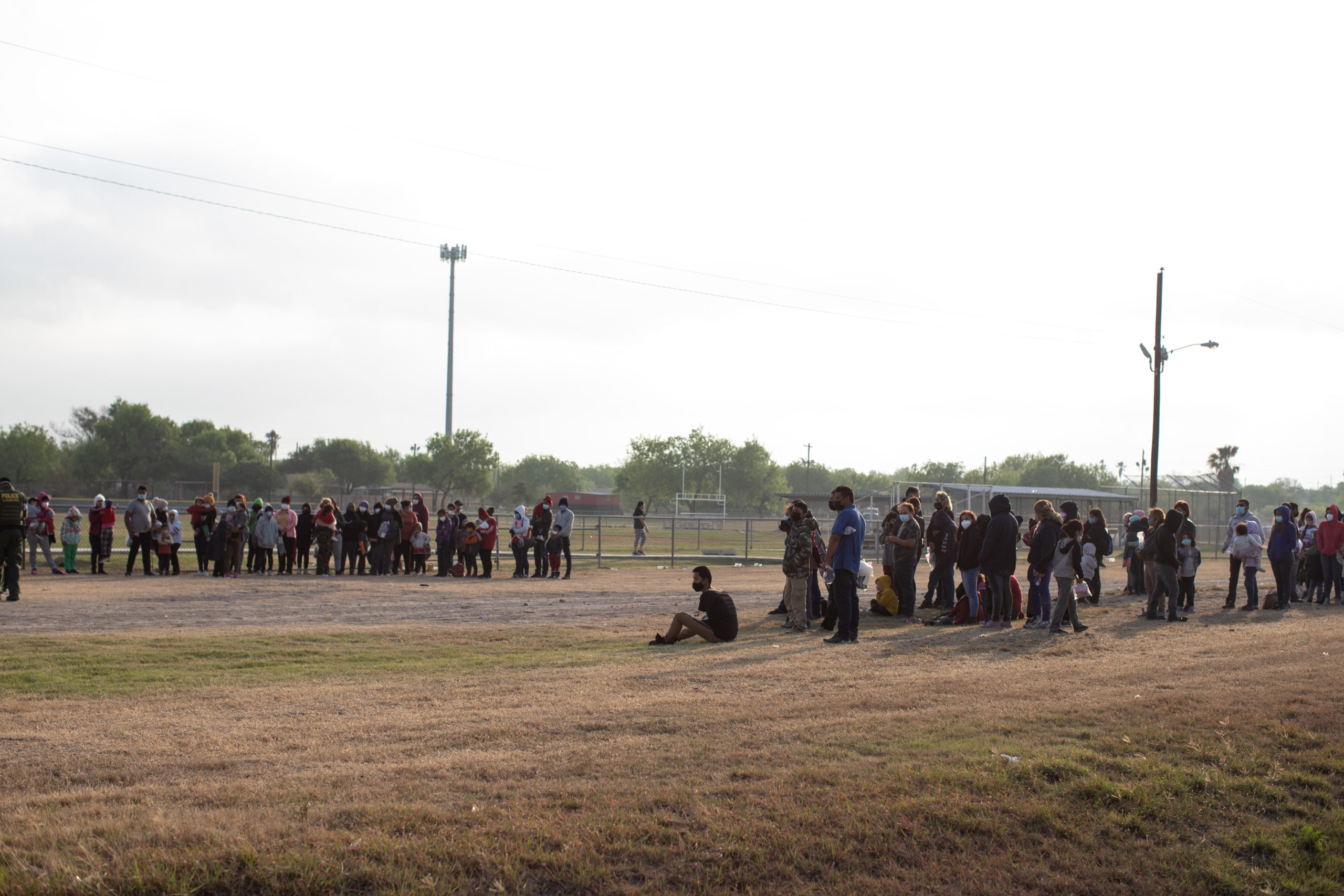 Illegal migrants wait on the side of a public road to be processed and taken to Customs and Border Protection facilities in La Joya, Texas on March 27, 2021. (Kaylee Greenlee - Daily Caller News Foundation)