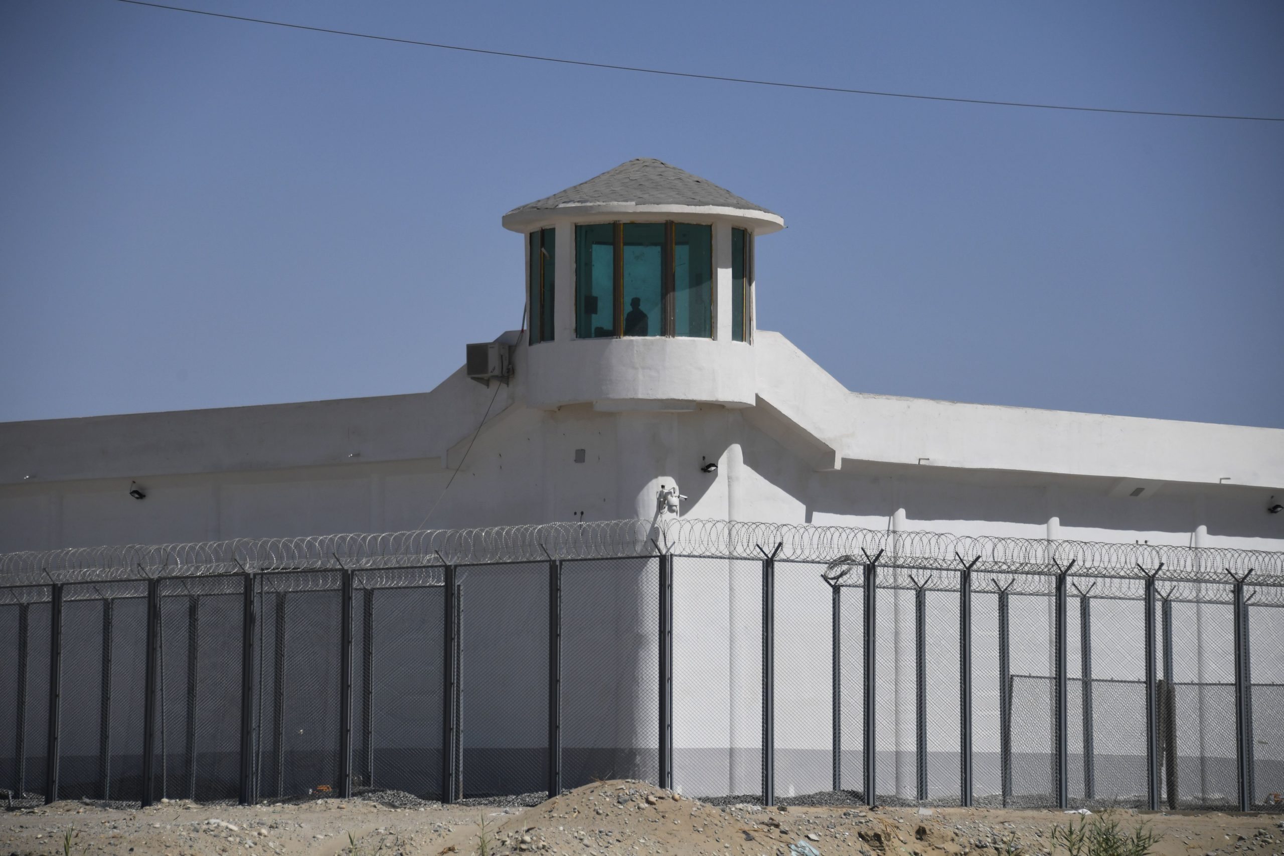 TOPSHOT - This photo taken on May 31, 2019 shows a watchtower on a high-security facility near what is believed to be a re-education camp where mostly Muslim ethnic minorities are detained, on the outskirts of Hotan, in China's northwestern Xinjiang region. - As many as one million ethnic Uighurs and other mostly Muslim minorities are believed to be held in a network of internment camps in Xinjiang, but China has not given any figures and describes the facilities as "vocational education centres" aimed at steering people away from extremism. (Photo by GREG BAKER / AFP) / TO GO WITH AFP STORY CHINA-XINJIANG-MEDIA-RIGHTS-PRESS,FOCUS BY EVA XIAO (Photo credit should read GREG BAKER/AFP via Getty Images)