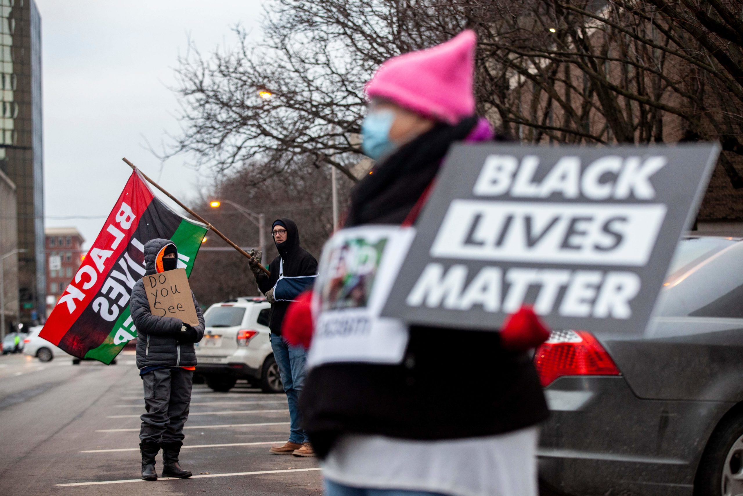 Protesters hold signs and flags during a demonstration against police brutality in front of the Fraternal Order of Police in Columbus, Ohio on December 28, 2020. - A white police officer who shot dead a Black man in Columbus, Ohio, last week was fired on December 28, city officials said. The death of Andre Maurice Hill triggered outrage in a country that has been racked by protests against police brutality and systemic racism since the spring. (Photo by STEPHEN ZENNER / AFP) (Photo by STEPHEN ZENNER/AFP via Getty Images)