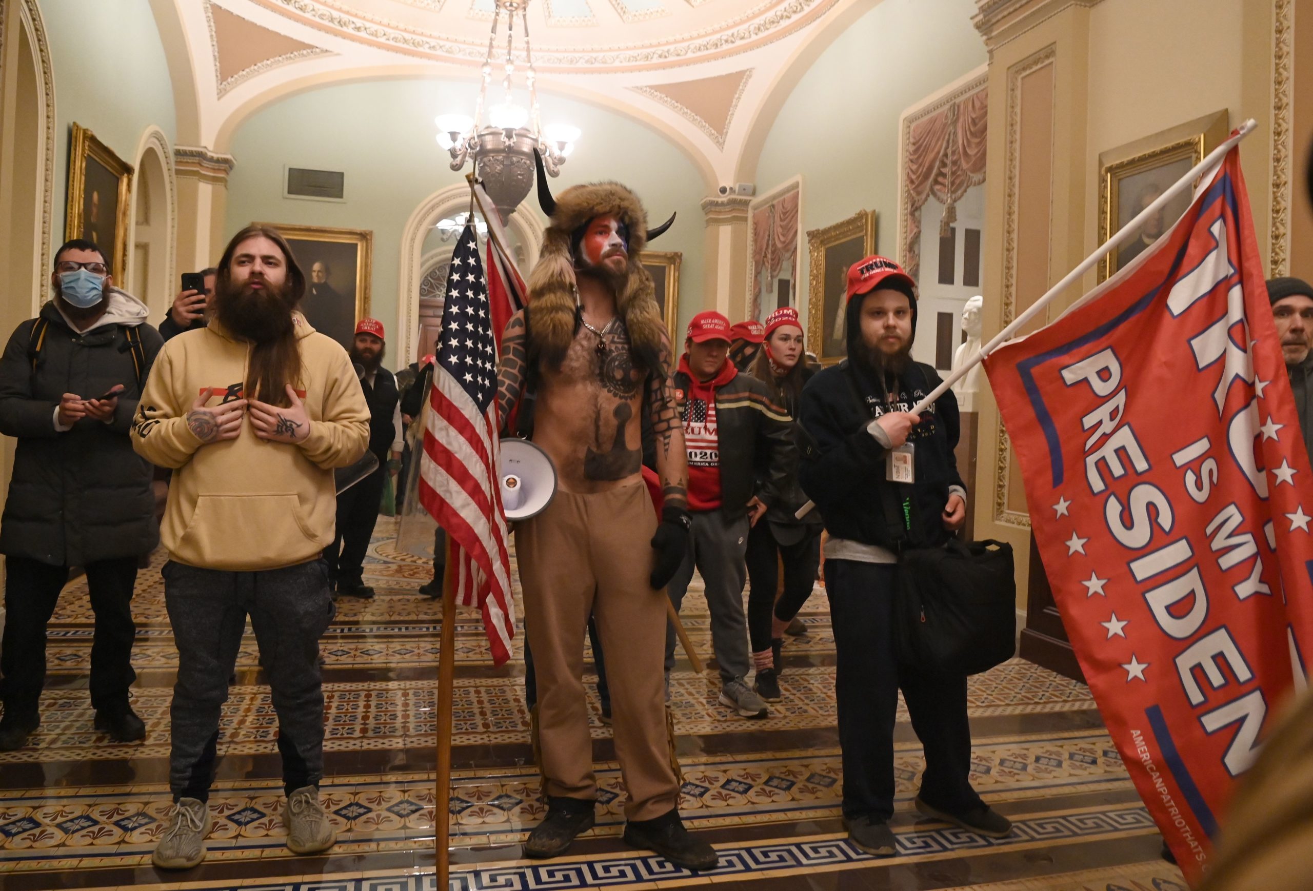 TOPSHOT - Supporters of US President Donald Trump, including member of the QAnon conspiracy group Jake Angeli, aka Yellowstone Wolf (C), enter the US Capitol on January 6, 2021, in Washington, DC. - Demonstrators breeched security and entered the Capitol as Congress debated the a 2020 presidential election Electoral Vote Certification. (Photo by Saul LOEB / AFP) (Photo by SAUL LOEB/AFP via Getty Images)