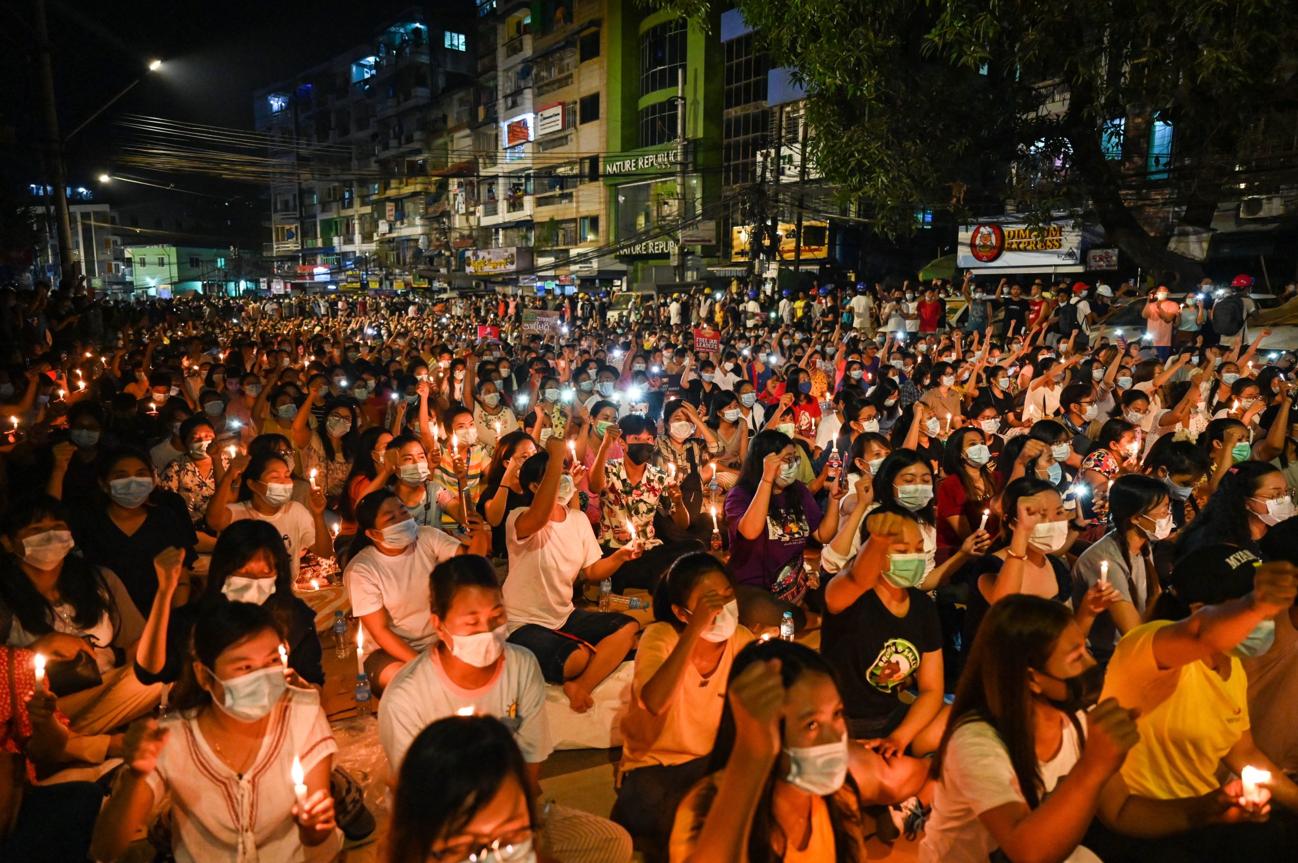 Protesters gesture during a candlelight vigil to honour those who have died during demonstrations against the military coup in Yangon on March 13, 2021. (Photo by STR / AFP) (Photo by STR/AFP via Getty Images)