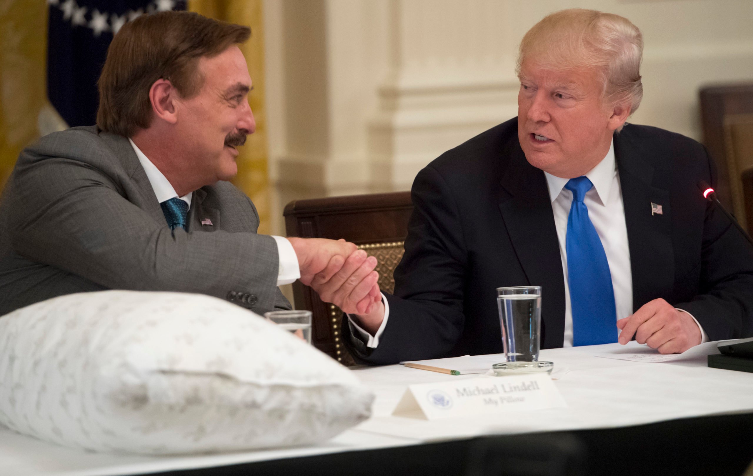 US President Donald Trump shakes hands with Mike Lindell (L), founder of My Pillow, during a Made in America event with US manufacturers in the East Room of the White House in Washington, DC, July 19, 2017. (SAUL LOEB/AFP via Getty Images)