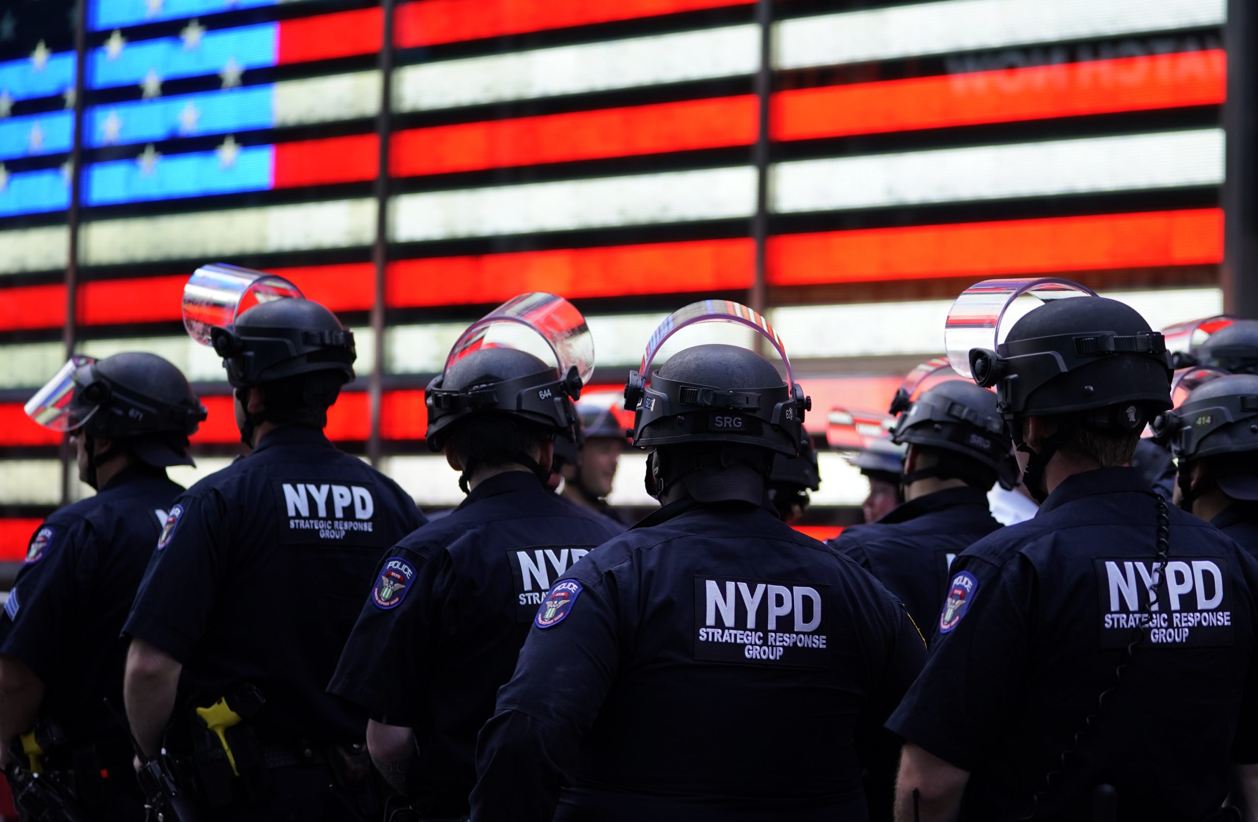 TOPSHOT - NYPD police officers watch demonstrators in Times Square on June 1, 2020, during a "Black Lives Matter" protest. - New York's mayor Bill de Blasio today declared a city curfew from 11:00 pm to 5:00 am, as sometimes violent anti-racism protests roil communities nationwide. Saying that "we support peaceful protest," De Blasio tweeted he had made the decision in consultation with the state's governor Andrew Cuomo, following the lead of many large US cities that instituted curfews in a bid to clamp down on violence and looting. (Photo by TIMOTHY A. CLARY / AFP) (Photo by TIMOTHY A. CLARY/AFP via Getty Images)