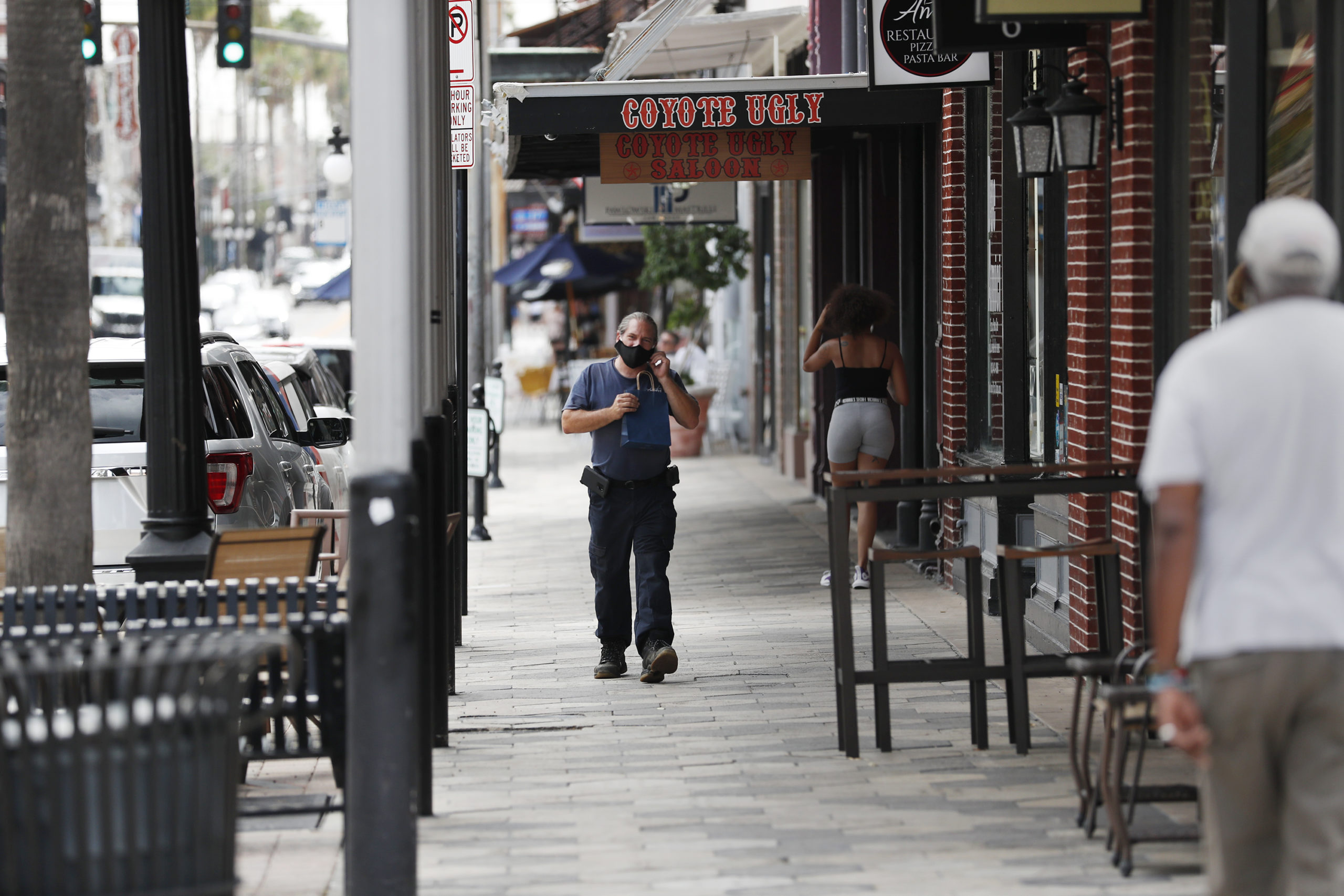 TAMPA, FL - JUNE 26: A unidentified man wearing a mask walks on 7th Avenue in the Ybor City neighborhood on June 26, 2020 in Tampa, Florida. Florida surpasses previous single-day high for positive coronavirus cases on Friday, recording 8,942 new infections over the course of 24 hours, according to Florida Department of Health statistics. (Photo by Octavio Jones/Getty Images)