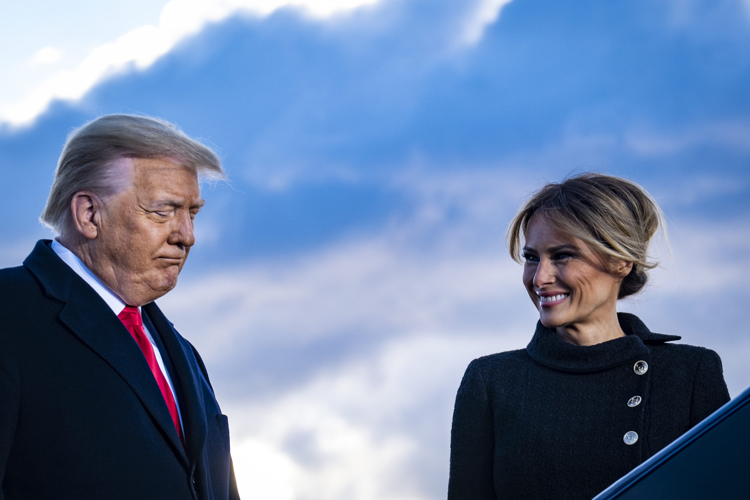President Donald Trump and First Lady Melania Trump pause while speaking to supporters at Joint Base Andrews before boarding Air Force One for his last time as President on January 20, 2021 in Joint Base Andrews, Maryland. (Pete Marovich - Pool/Getty Images)