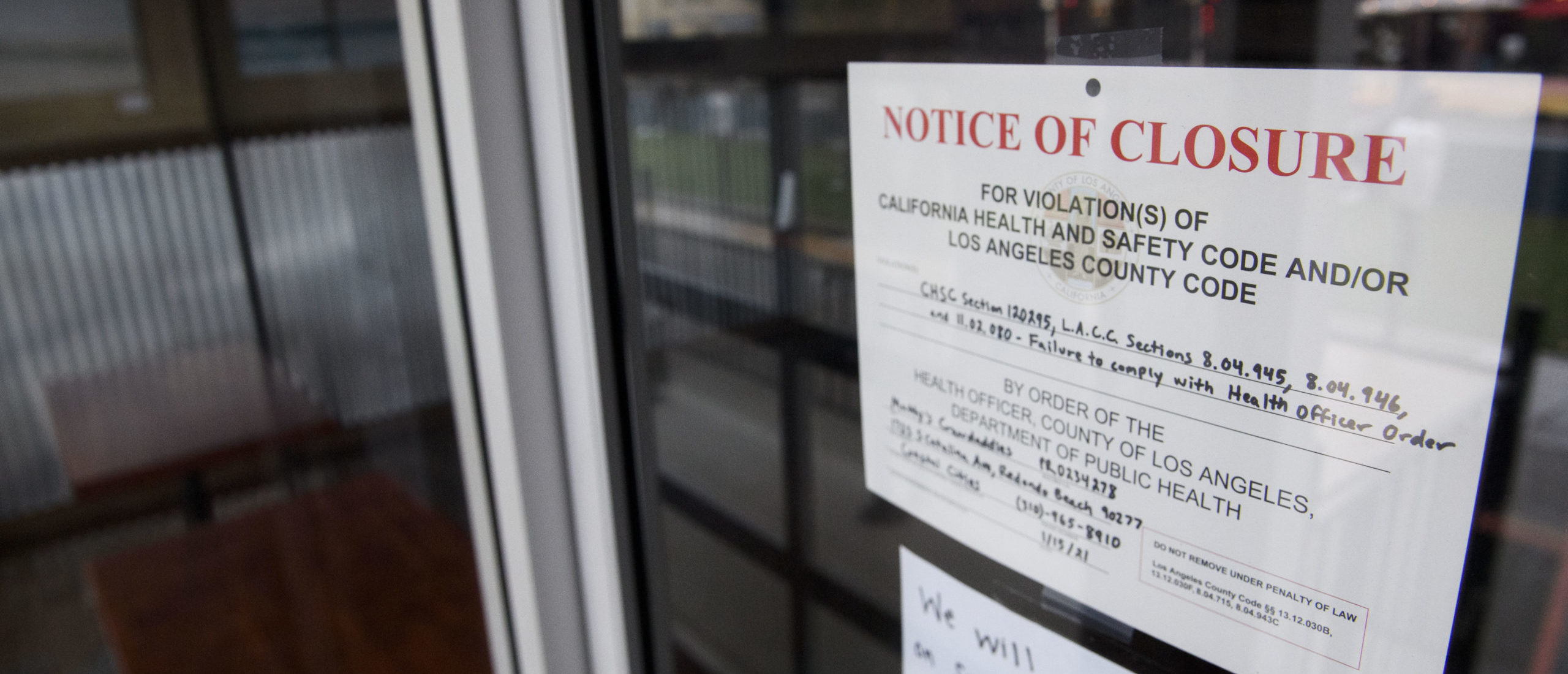 A County of Los Angeles Department of Public Health "Notice of Closure" sign hangs on the door of a restaurant temporality closed due to violations including "failure to comply with health officer order" amid increased Covid-19 restrictions on businesses on January 22, 2021 in Redondo Beach, California. (Photo by PATRICK T. FALLON/AFP via Getty Images)