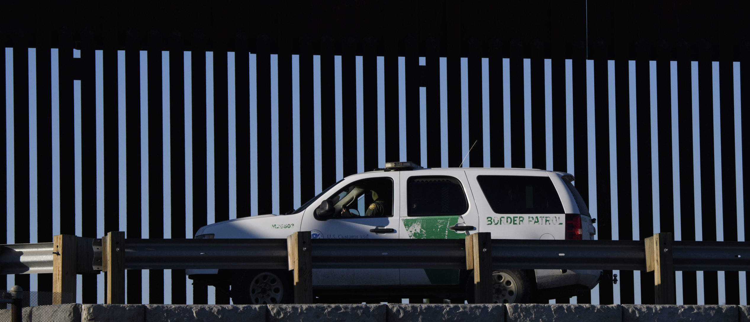 A US Border Patrol agent sits in a vehicle along a border wall near the US Customs and Border Protection (CBP) San Ysidro Port of Entry at the US Mexico border on February 19, 2021 in San Diego, California. - The Biden administration plans to slowly allow 25,000 people with active cases seeking asylum into the US previously enrolled in the Migrant Protection Protocols program, known as "Remain in Mexico," with community organizations testing for Covid-19 and providing hotels to quarantine migrants upon arrival during the pandemic. (Photo by Patrick T. FALLON / AFP) (Photo by PATRICK T. FALLON/AFP via Getty Images)