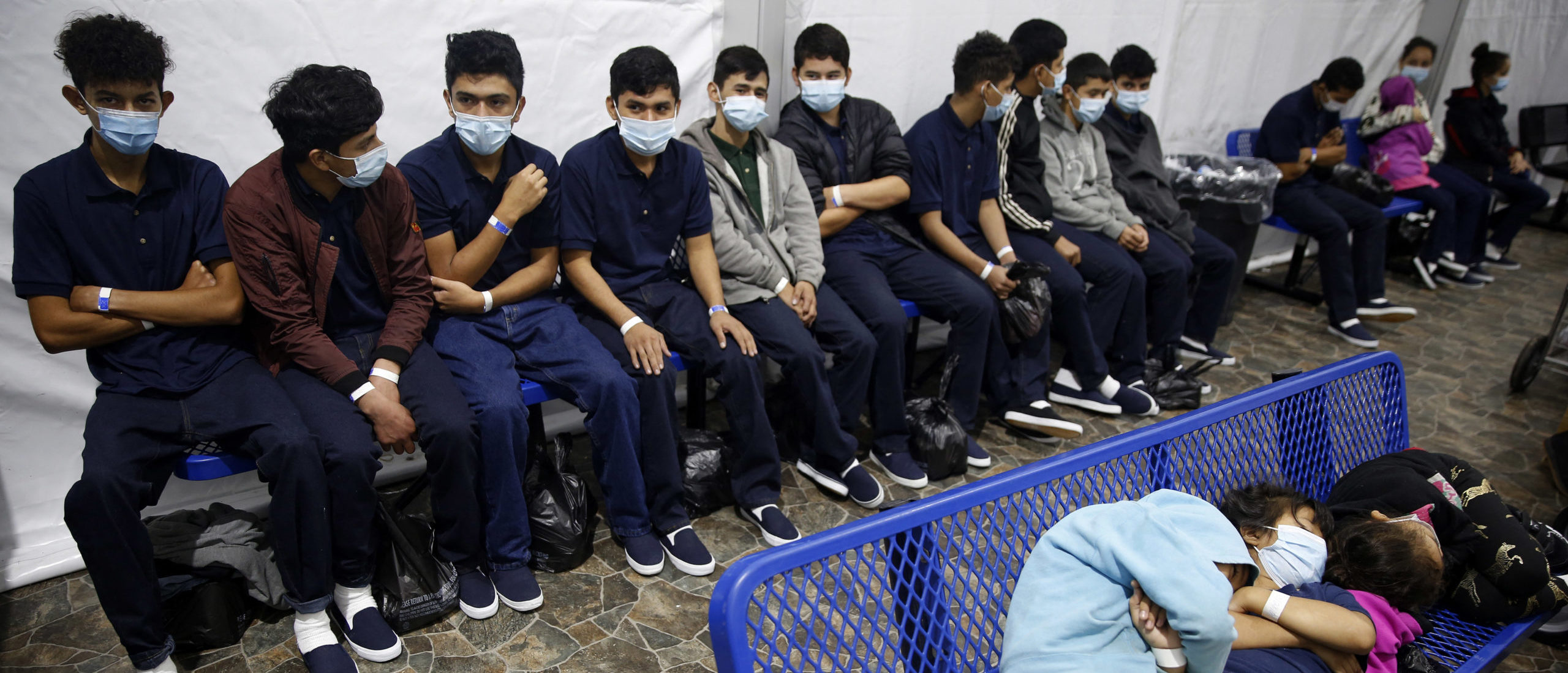 Young unaccompanied migrants, wait for their turn at the secondary processing station inside the Donna Department of Homeland Security holding facility, the main detention center for unaccompanied children in the Rio Grande Valley in Donna, Texas on March 30, 2021. - The Biden administration on Tuesday for the first time allowed journalists inside its main detention facility at the border for migrant children, revealing a severely overcrowded tent structure where more than 4,000 kids and families were crammed into pods and the youngest kept in a large play pen with mats on the floor for sleeping. (Photo by Dario Lopez-Mills / POOL / AFP) (Photo by DARIO LOPEZ-MILLS/POOL/AFP via Getty Images)