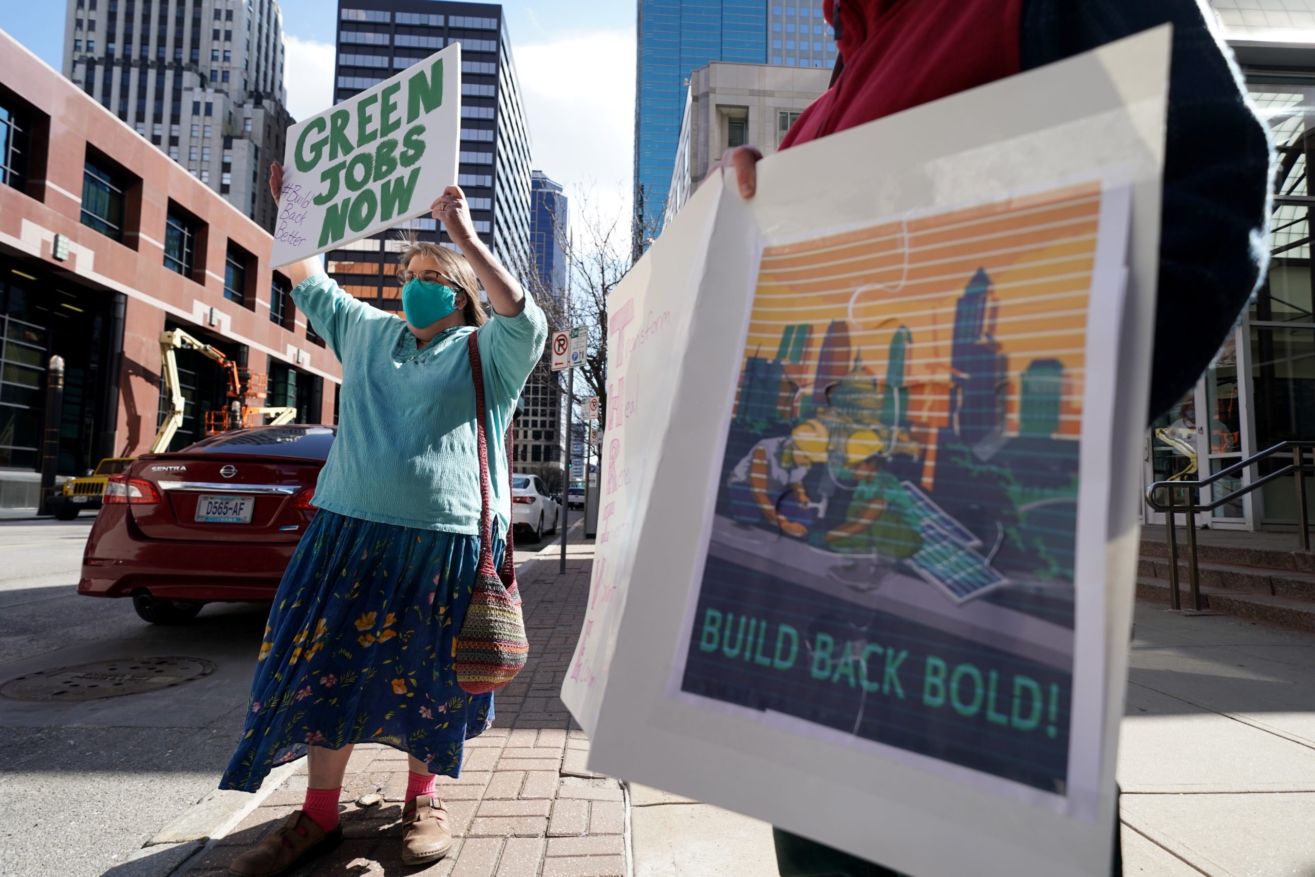 Supporters of President Joe Biden hold signs in favor of his $2.3 trillion infrastructure plan on Wednesday. (Ed Zurga/Getty Images for Green New Deal Network)