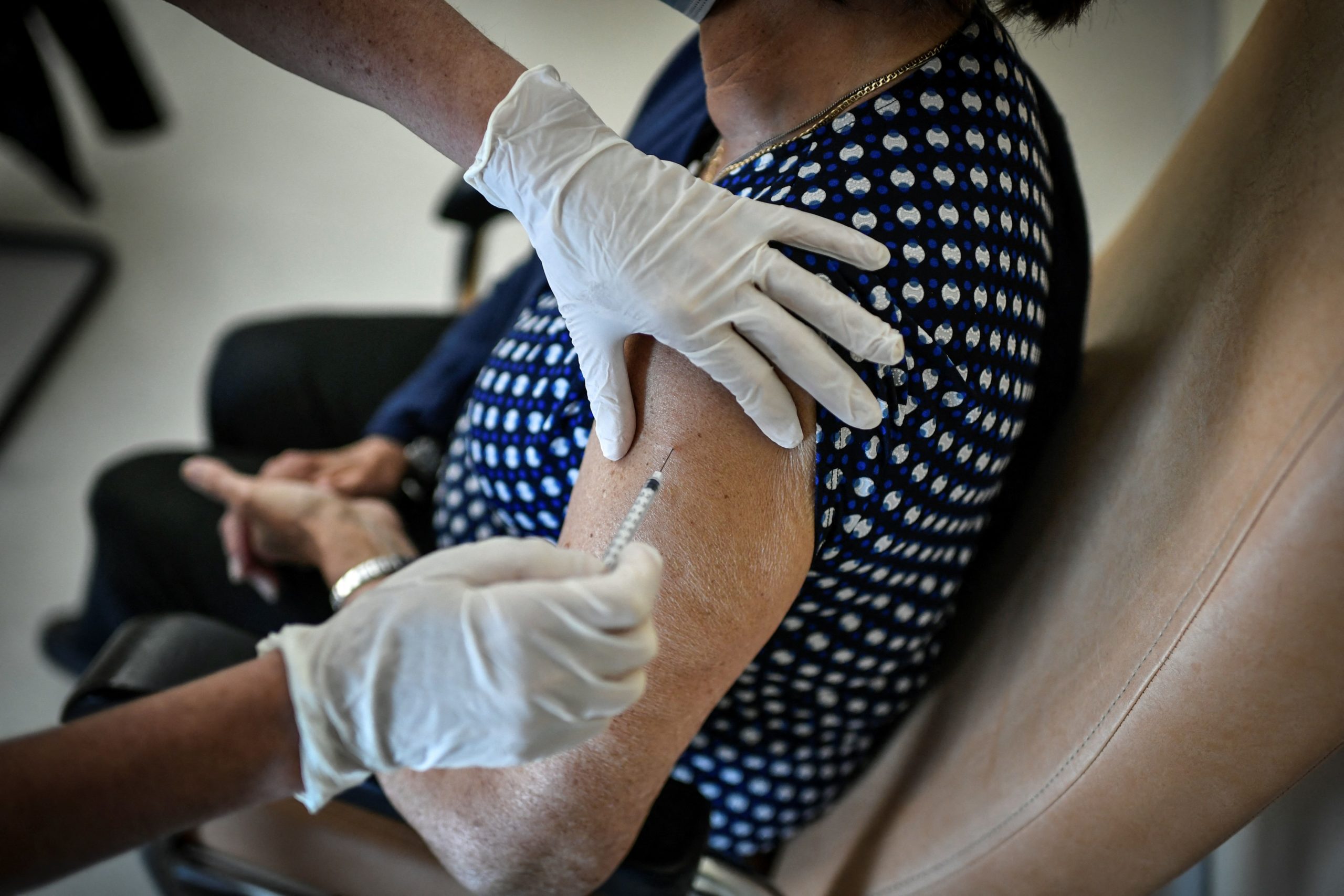 A woman receives a dose of the Pfizer-BioNTech vaccine against the Covid-19 at Begin military hospital in Saint-Mande, east of Paris, a day after the vaccination by military personnel started in the country on April 7, 2021. (Photo by STEPHANE DE SAKUTIN / AFP) (Photo by STEPHANE DE SAKUTIN/AFP via Getty Images)