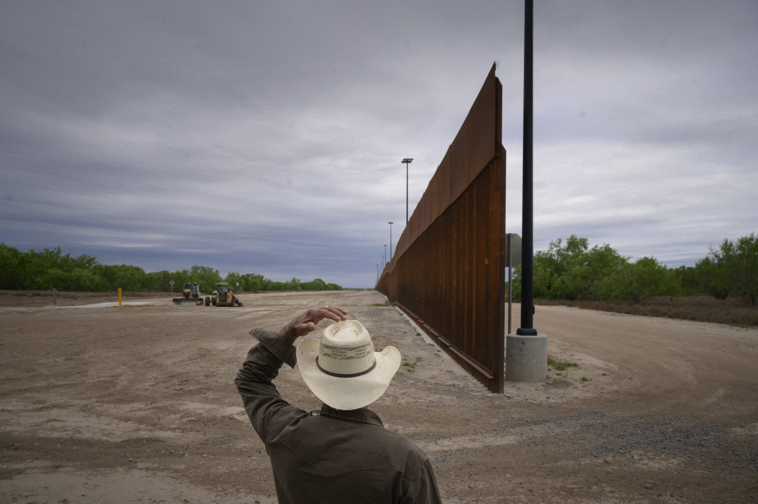 In a photo taken on March 28, 2021 ranch owner Tony Sandoval (67) stands before a portion of the unfinished border wall that former US President Donald Trump tried to build, near the southern Texas border city of Roma. (Photo by ED JONES/AFP via Getty Images)