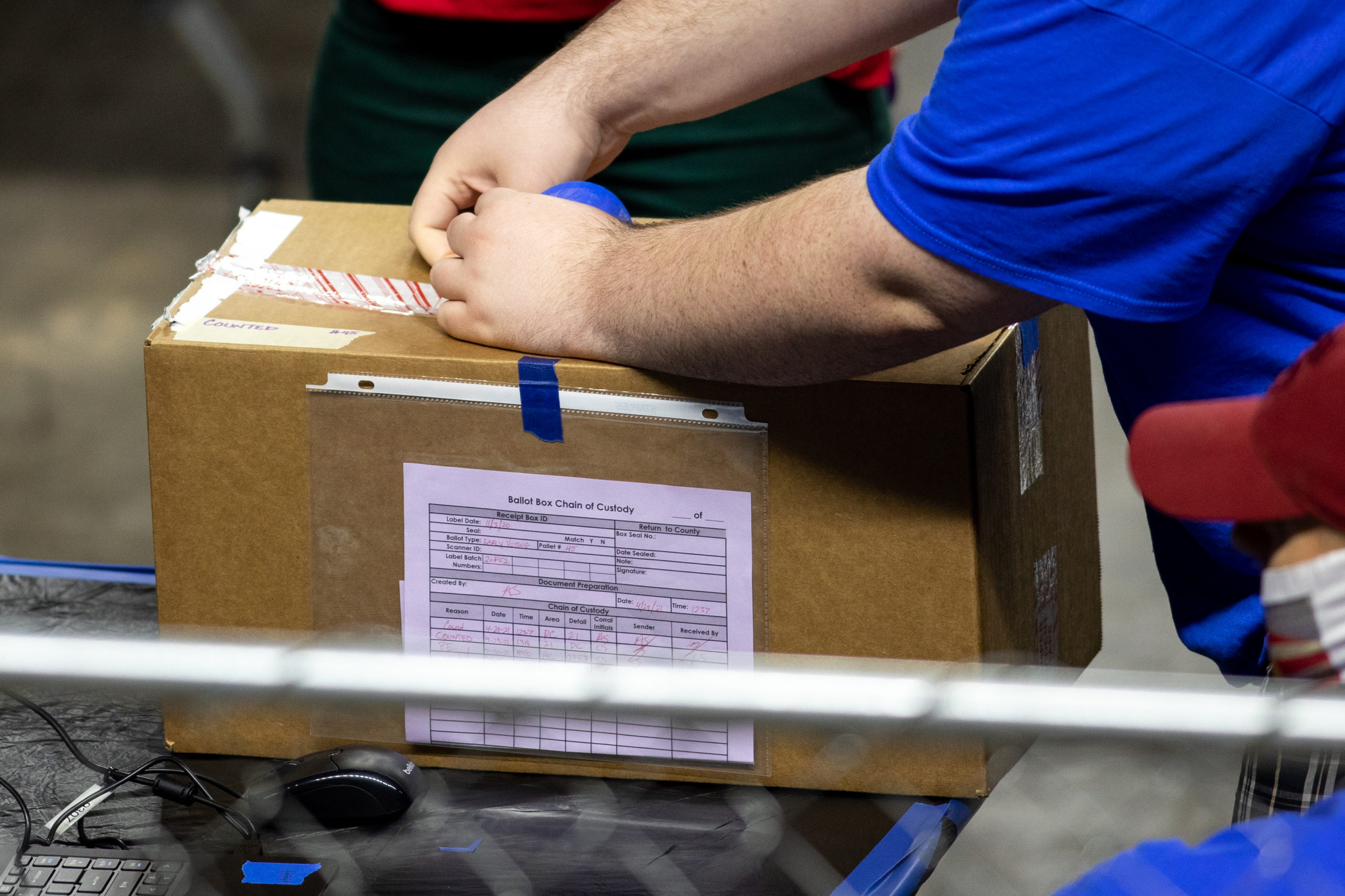 A contractor working for Cyber Ninjas, a firm hired by the Arizona State Senate, unboxes ballots from the 2020 election on May 1. (Courtney Pedroza/Getty Images)