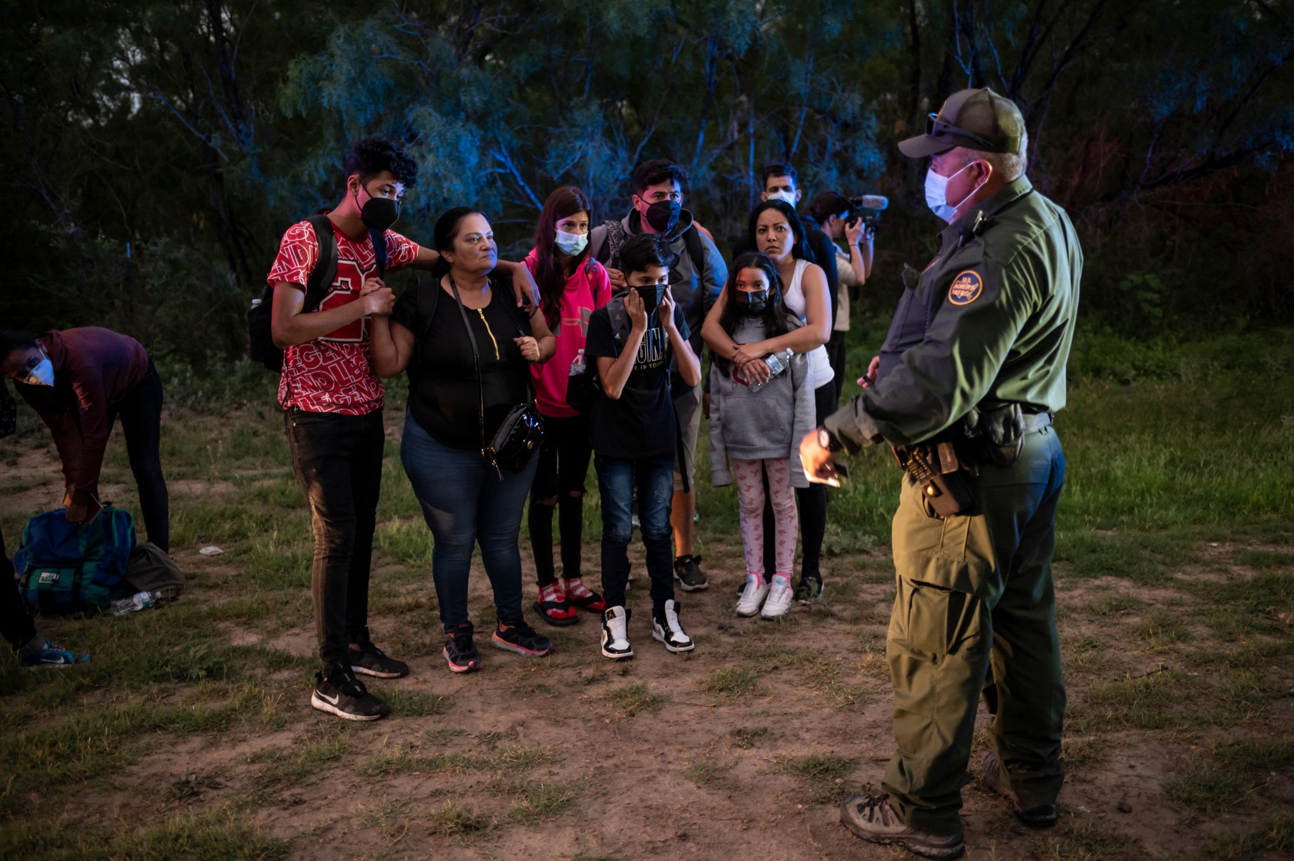 A migrant family waits to be processed after being apprehended near the border between Mexico and the United States in Del Rio, Texas on May 16, 2021. (Photo by SERGIO FLORES/AFP via Getty Images)