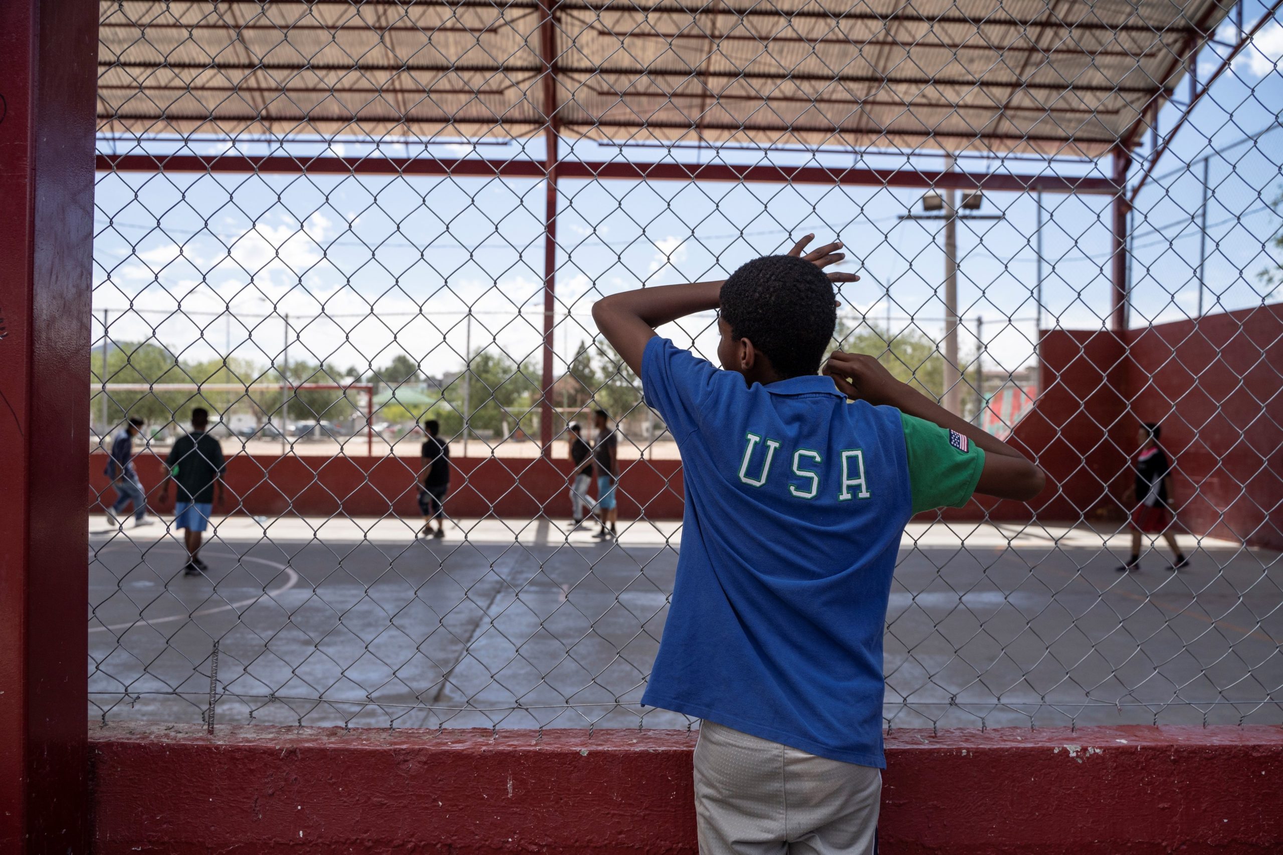 TOPSHOT - One of the residents of Iglesia Metodista "El Buen Pastor" migrant shelter watches the soccer match at a park near the shelter on June 09, 2019. (Photo credit should read PAUL RATJE/AFP via Getty Images)