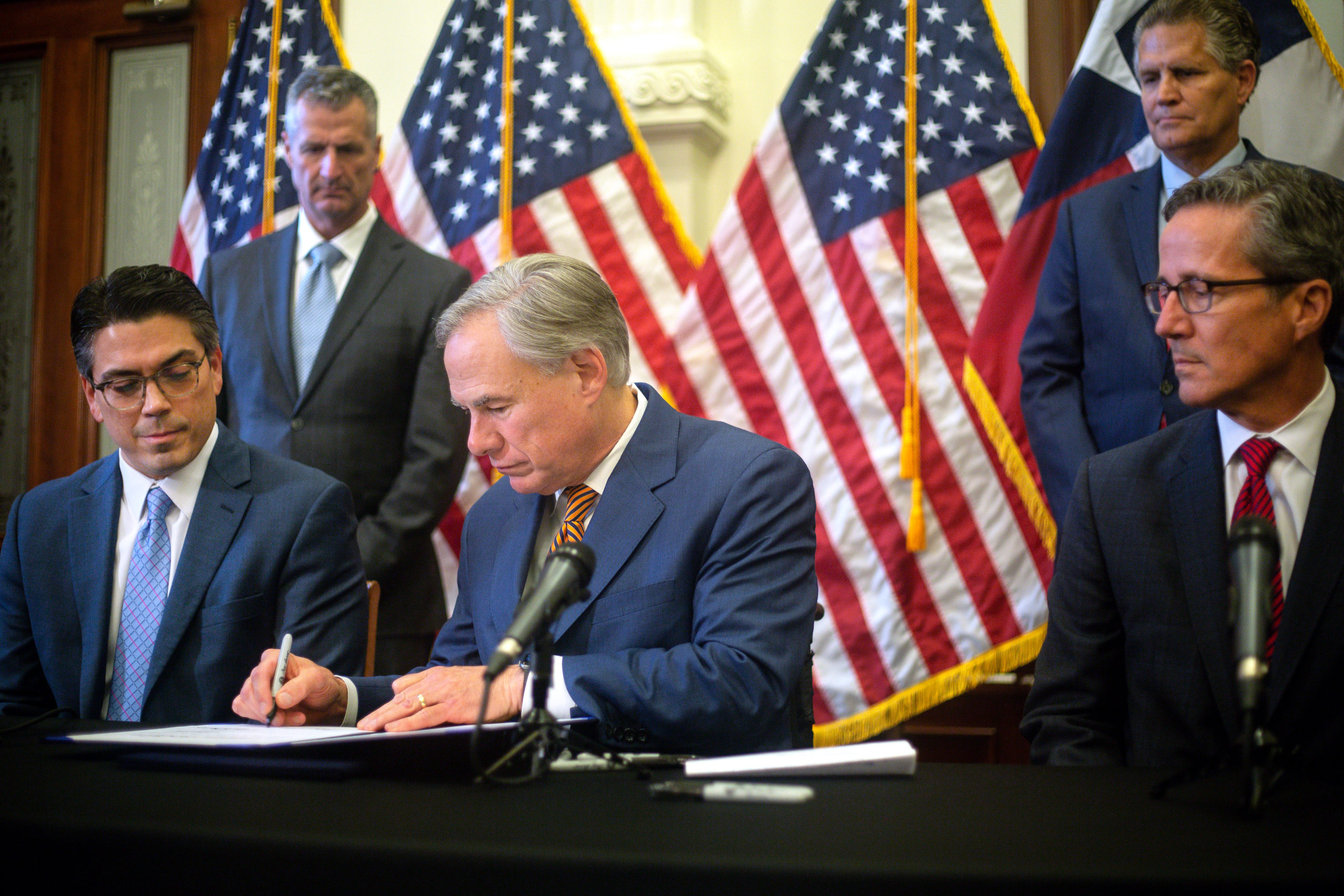 AUSTIN, TX - JUNE 08: State Rep. Chris Paddie (L) and State Senator Kelly Hancock (R) watch as Texas Governor Greg Abbott signs Senate Bills 2 and 3 during a press conference at the Capitol on June 8, 2021 in Austin, Texas. Governor Abbott signed the bills into law to reform the Electric Reliability Council of Texas and weatherize and improve the reliability of the state's power grid. The bill signing comes months after a disastrous February winter storm that caused widespread power outages and left dozens of Texans dead. (Photo by Montinique Monroe/Getty Images)