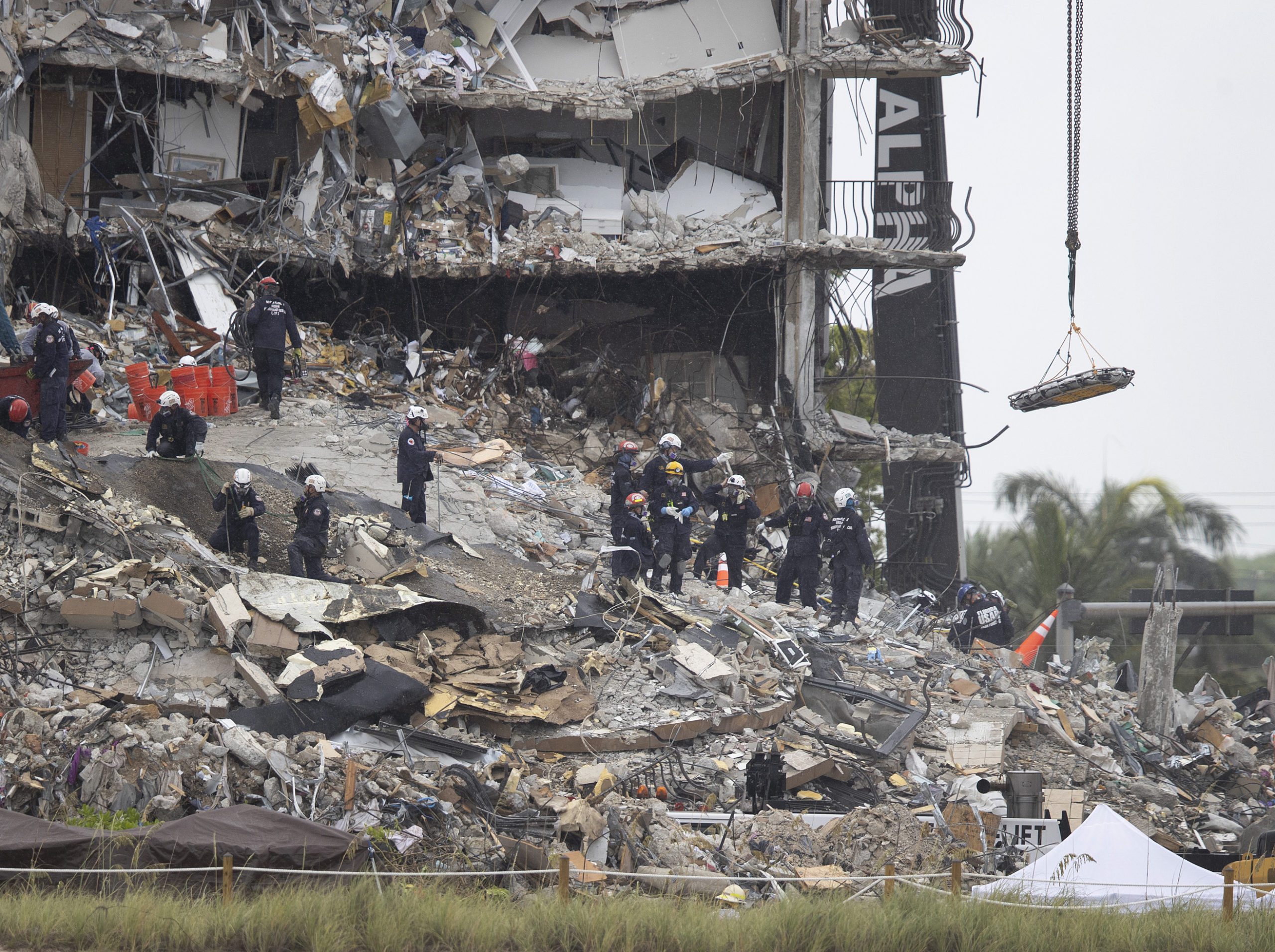 As Search and Rescue personnel continue to look through the rubble a crane removes a stretcher from the partially collapsed 12-story Champlain Towers South condo building on June 28, 2021 in Surfside, Florida. (Joe Raedle/Getty Images)