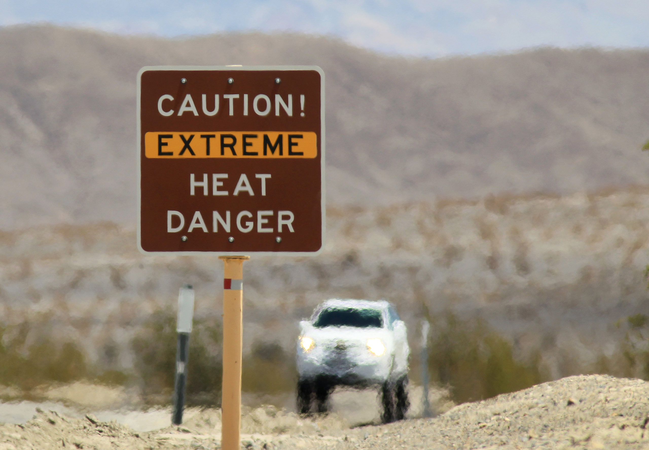 DEATH VALLEY NATIONAL PARK, CA JULY 14: Heat waves rise near a heat danger warning sign on the eve of the AdventurCORPS Badwater 135 ultra-marathon race on July 14, 2013 in Death Valley National Park, California. Billed as the toughest footrace in the world, the 36th annual Badwater 135 starts at Badwater Basin in Death Valley, 280 feet below sea level, where athletes begin a 135-mile non-stop run over three mountain ranges in extreme mid-summer desert heat to finish at 8,350-foot near Mount Whitney for a total cumulative vertical ascent of 13,000 feet. July 10 marked the 100-year anniversary of the all-time hottest world record temperature of 134 degrees, set in Death Valley where the average high in July is 116. A total of 96 competitors from 22 nations are attempting the run which equals about five back-to-back marathons. Previous winners have completed all 135 miles in slightly less than 24 hours. (Photo by David McNew/Getty Images)