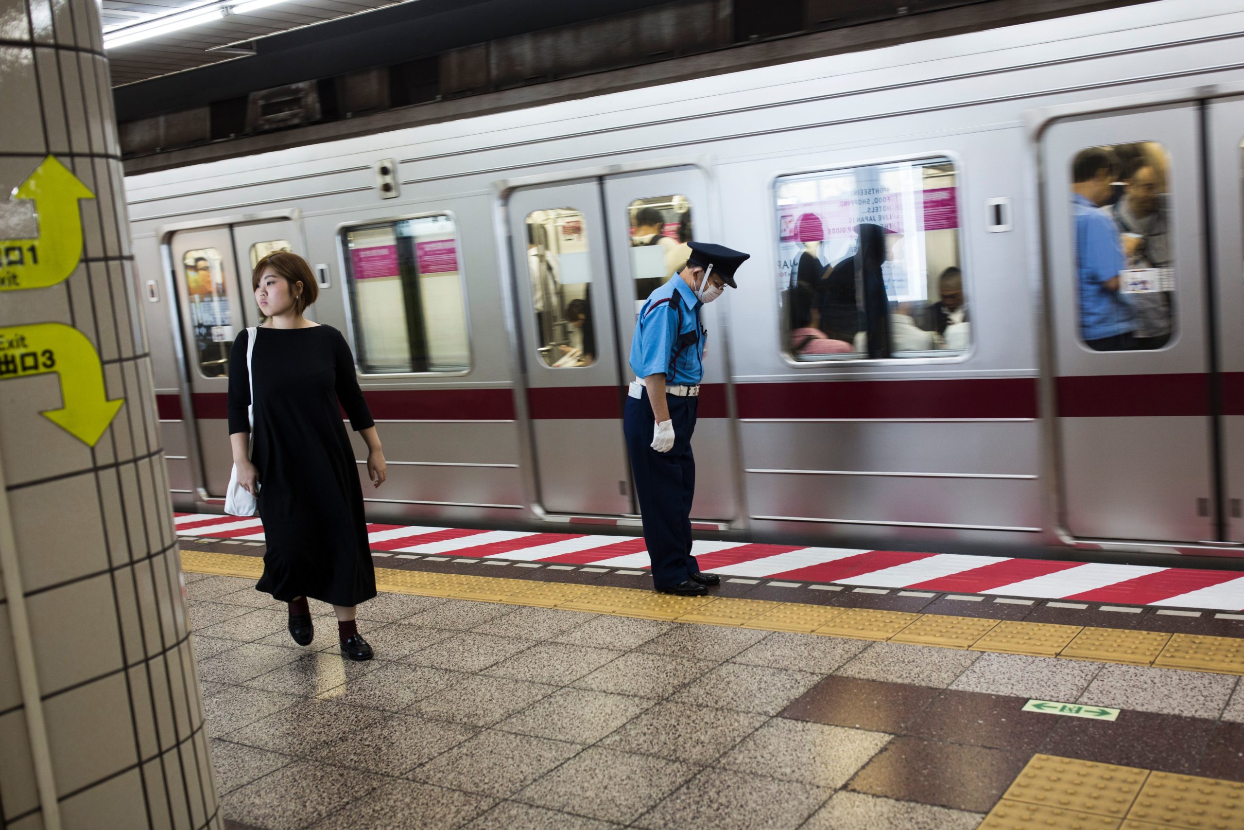 A Japanese subway employee bows next to a train after a safety check in a subway station in central Tokyo on October 12, 2016. / AFP / BEHROUZ MEHRI (Photo credit should read BEHROUZ MEHRI/AFP via Getty Images)