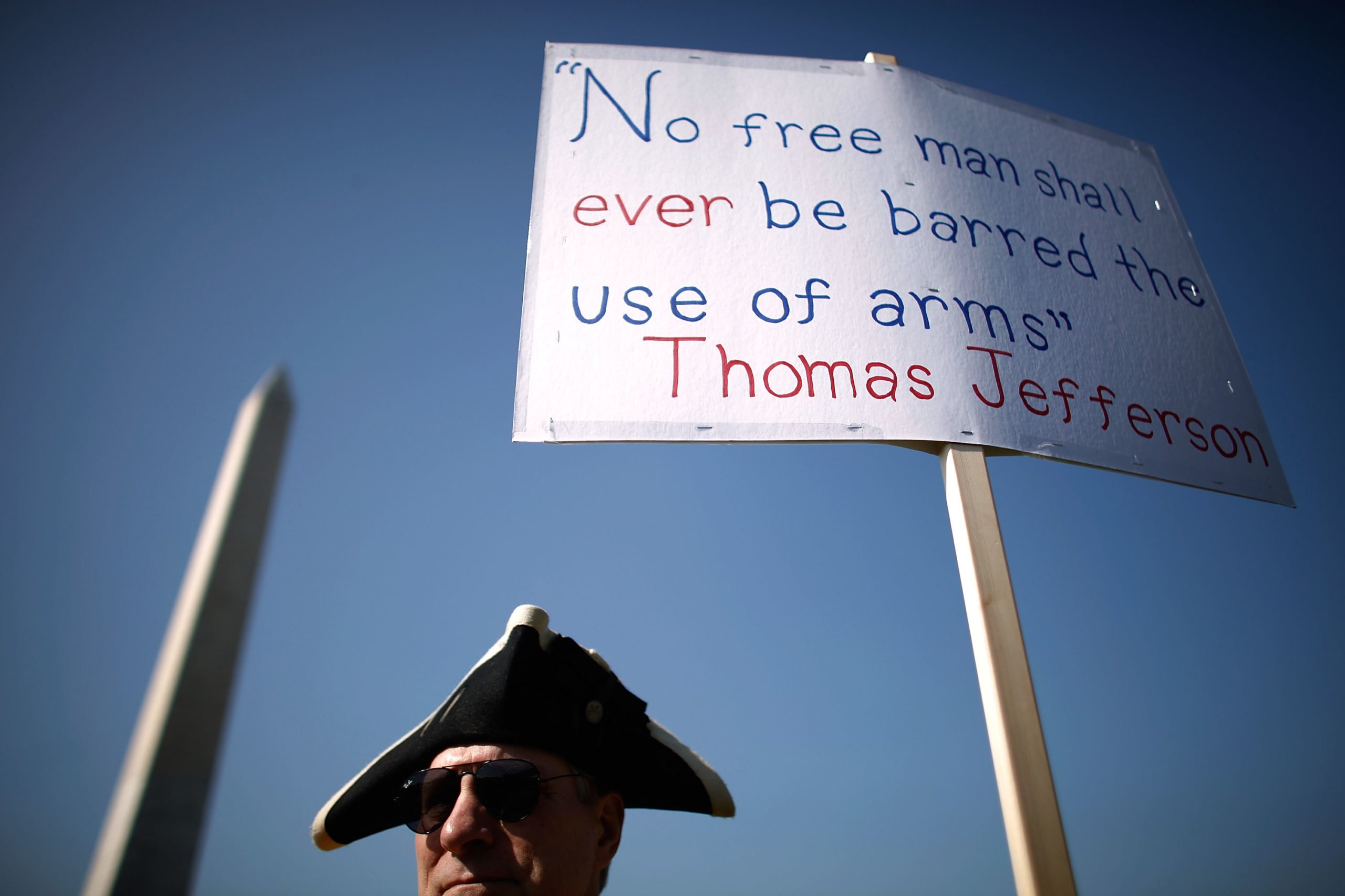 WASHINGTON - APRIL 19: A man stands next to a sign pro-gun rally organized by the Second Amendment March group, near the Washington Monument April 19, 2010 in Washington, DC. Known as Patriots' Day, April 19 is also the anniversary of the American Revolutionary War battles of Lexington and Concord, the Oklahoma City bombing and the attack of the Branch Dividian compound. (Photo by Chip Somodevilla/Getty Images)