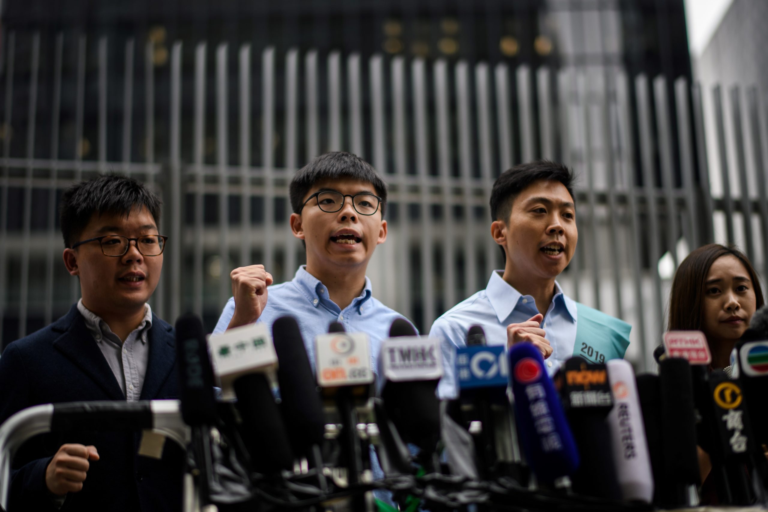 Pro-democracy activist Joshua Wong (2nd L) and Kelvin Lam (2nd R) shout slogans as they meet the media outside the Legislative Council (LegCo) in Hong Kong on October 29, 2019, after he was barred from standing in an upcoming local election. Wong was barred on October 29 from standing in an upcoming local election, after months of huge and frequently violent protests in the city. (Photo by ANTHONY WALLACE/AFP via Getty Images)