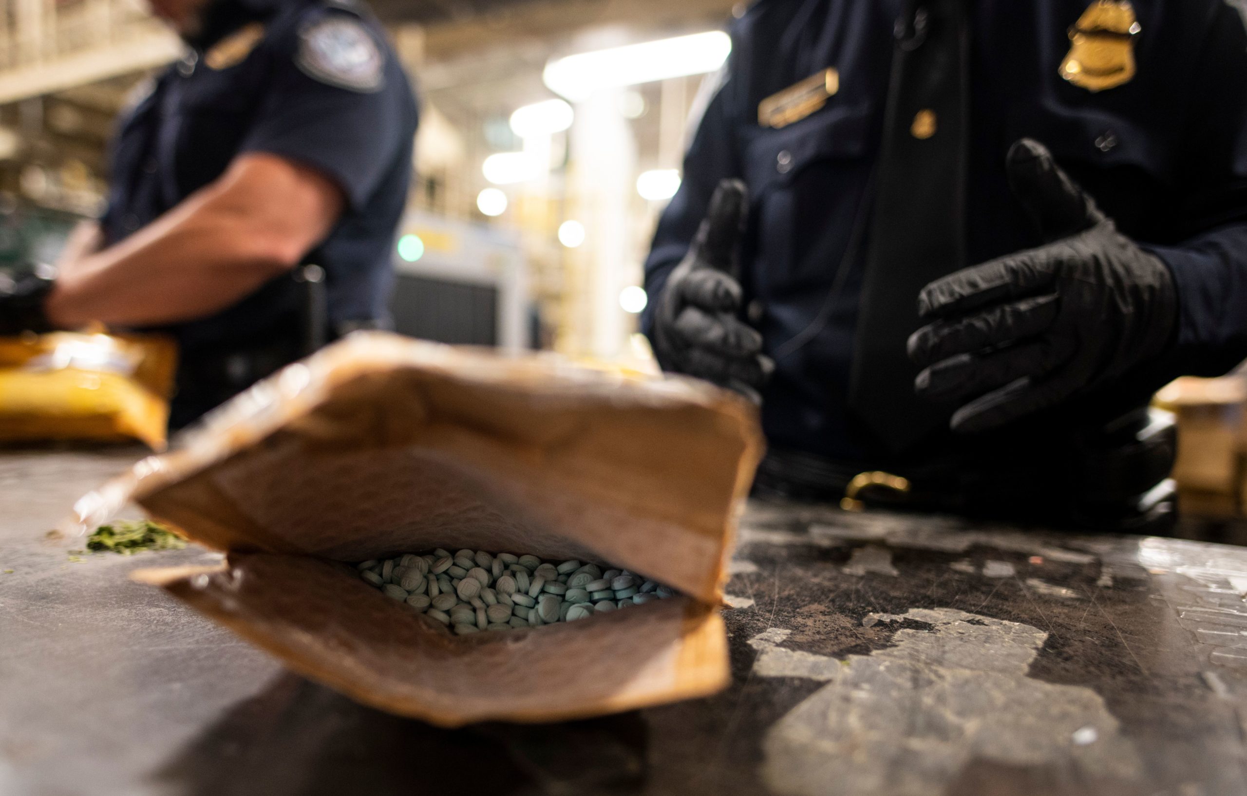 An officer from the US Customs and Border Protection, Trade and Cargo Division finds Oxycodon pills in a parcel at John F. Kennedy Airport's US Postal Service facility on June 24, 2019 in New York. (Photo by JOHANNES EISELE/AFP via Getty Images)