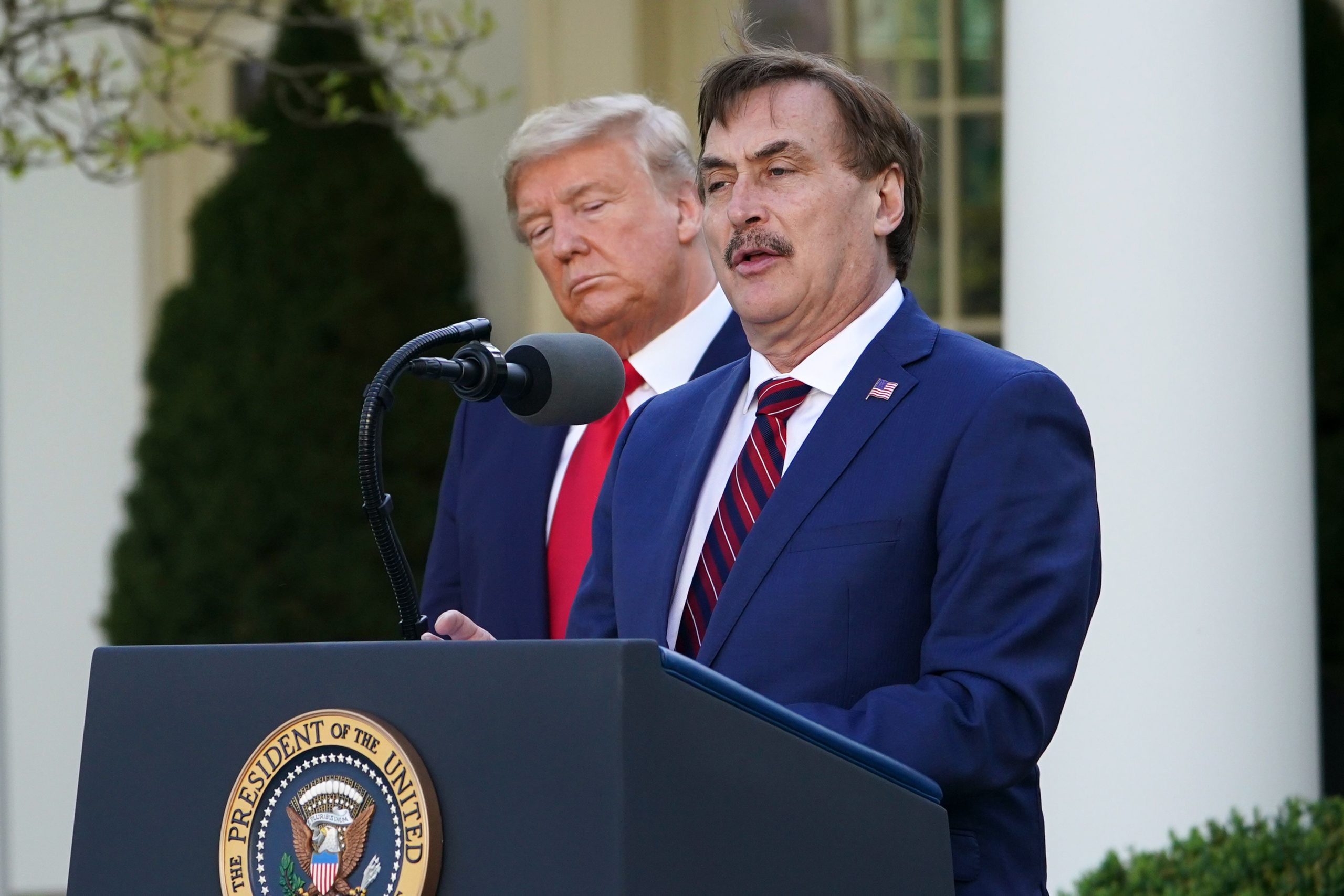 President Donald Trump listens as Mike Lindell, speaks during a coronavirus briefing in March 2020. (Mandel Ngan/AFP via Getty Images)