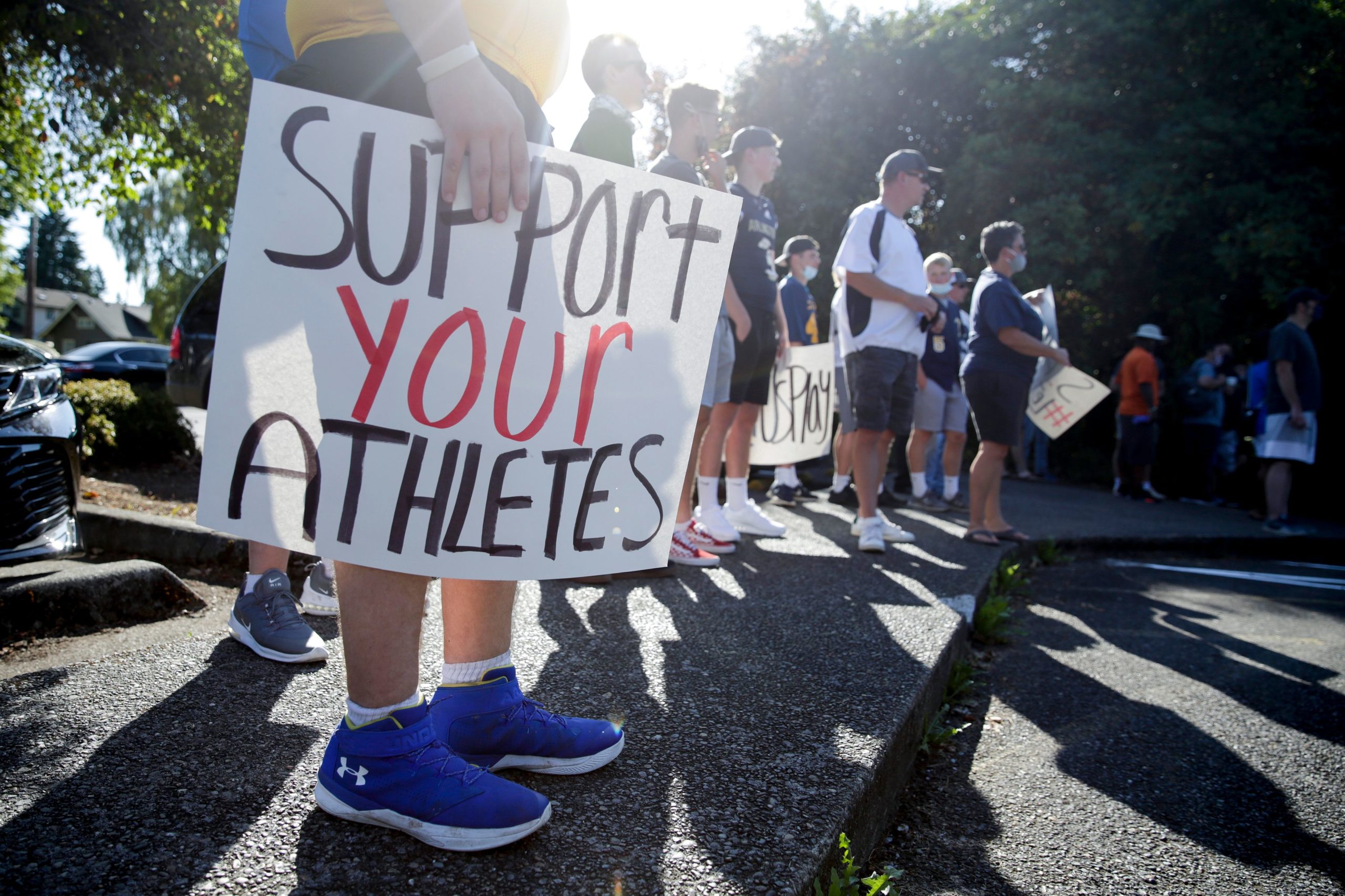 Athlete Zackery Schmeichel of Hazen High School holds a sign that reads "support your athletes" as people gather for a march and rally organized by Student Athletes of Washington (SAW), a group that formed to protest the postponement of fall sports due to COVID-19, at the state capitol in Olympia, Washington on September 3, 2020. (Photo by Jason Redmond / AFP) (Photo by JASON REDMOND/AFP via Getty Images)