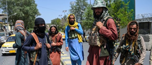 Taliban fighters stand guard along a street near the Zanbaq Square in Kabul on August 16, 2021, after a stunningly swift end to Afghanistan's 20-year war, as thousands of people mobbed the city's airport trying to flee the group's feared hardline brand of Islamist rule. (Photo by Wakil Kohsar / AFP) (Photo by WAKIL KOHSAR/AFP via Getty Images)