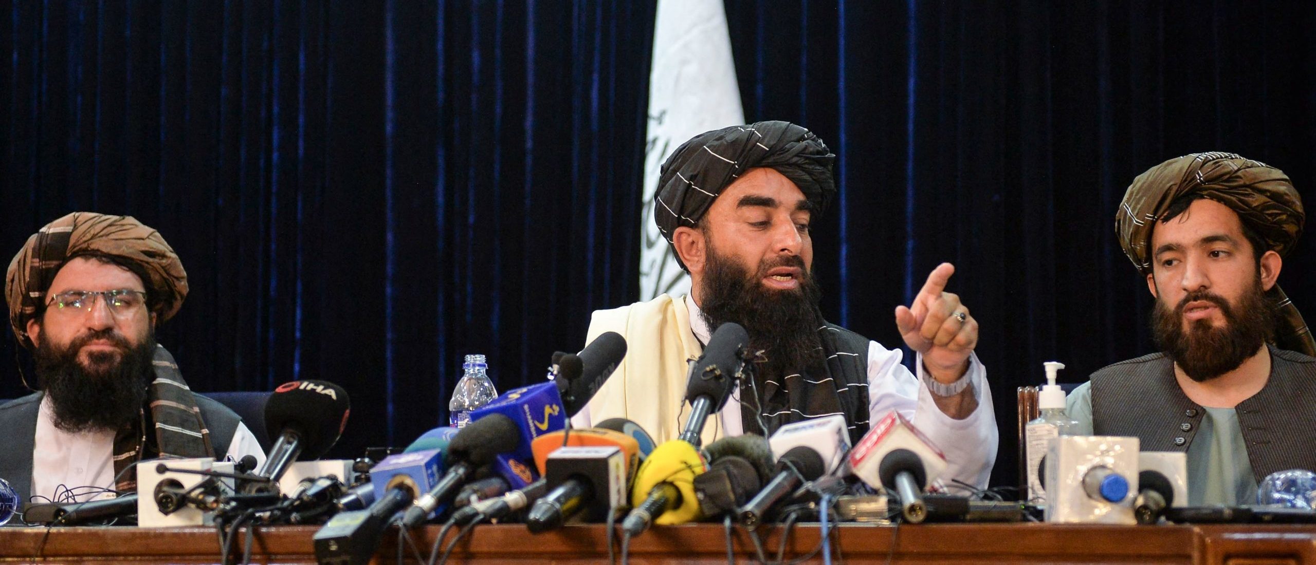 TOPSHOT - Taliban spokesperson Zabihullah Mujahid (C) gestures as he addresses the first press conference in Kabul on August 17, 2021 following the Taliban stunning takeover of Afghanistan. (Photo by Hoshang Hashimi / AFP) (Photo by HOSHANG HASHIMI/AFP via Getty Images)