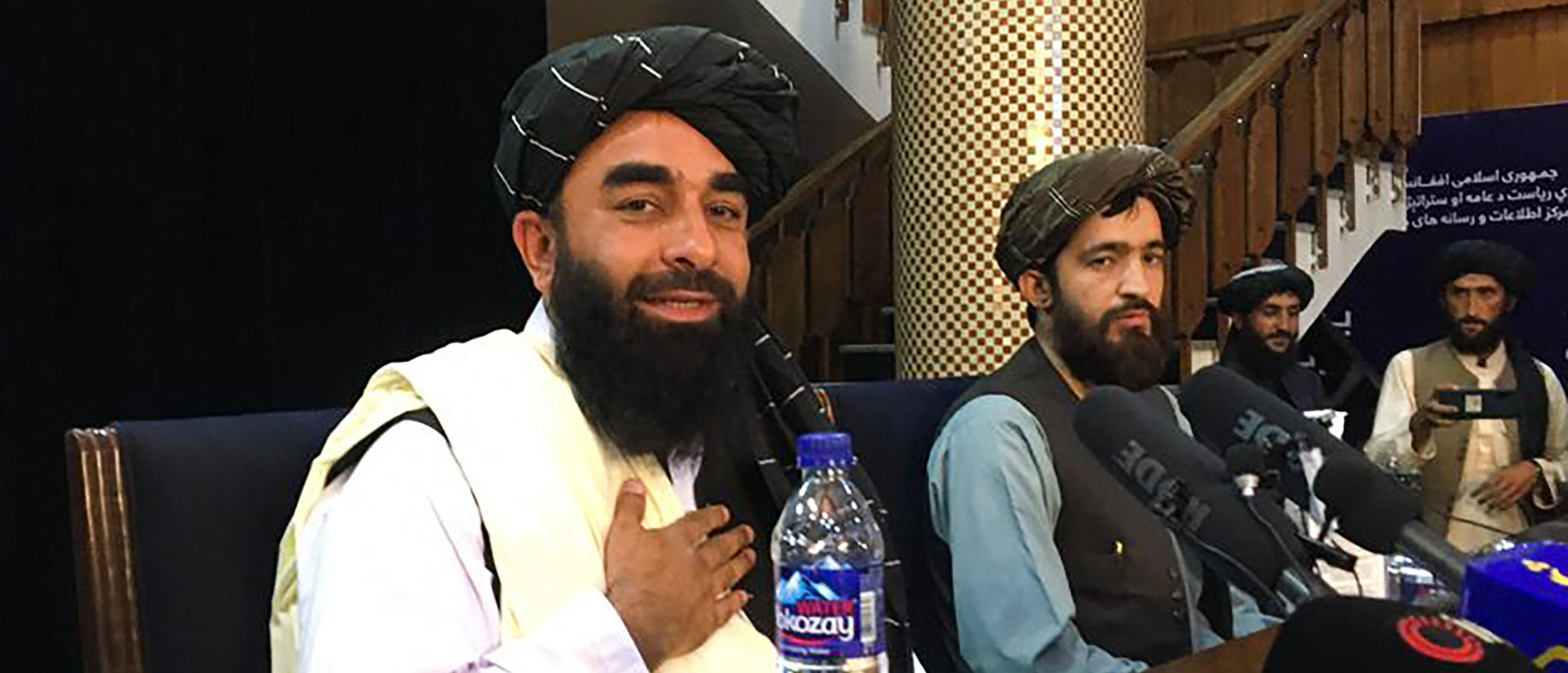 Taliban spokesperson Zabihullah Mujahid (L) attends the first press conference in Kabul on August 17, 2021, following their stunning takeover of Afghanistan. (Photo by HOSHANG HASHIMI/AFP via Getty Images)