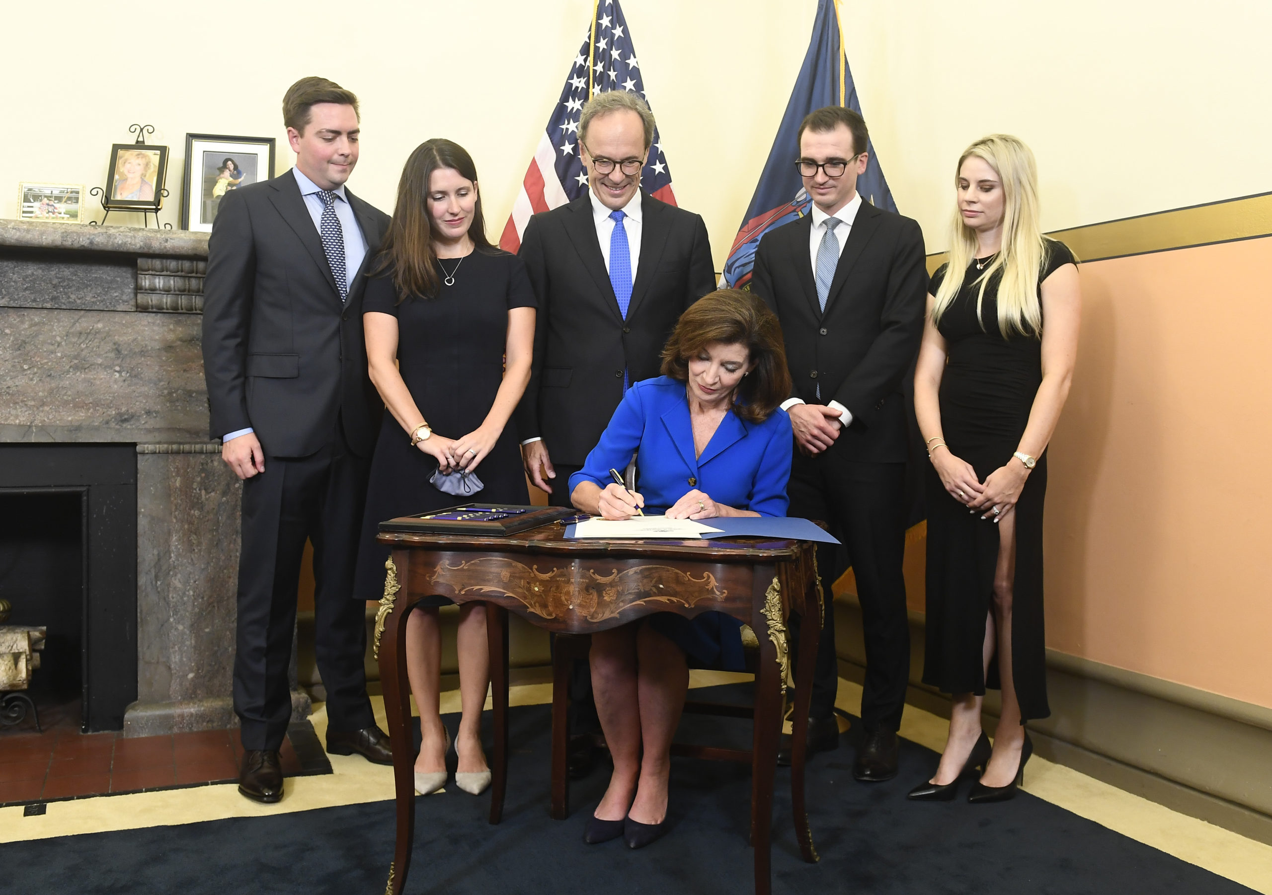 Family watches as New York Gov. Kathy Hochul signs documents at her swearing-in at the state Capitol in Albany, New York. (Hans Pennink-Pool/Getty Images)