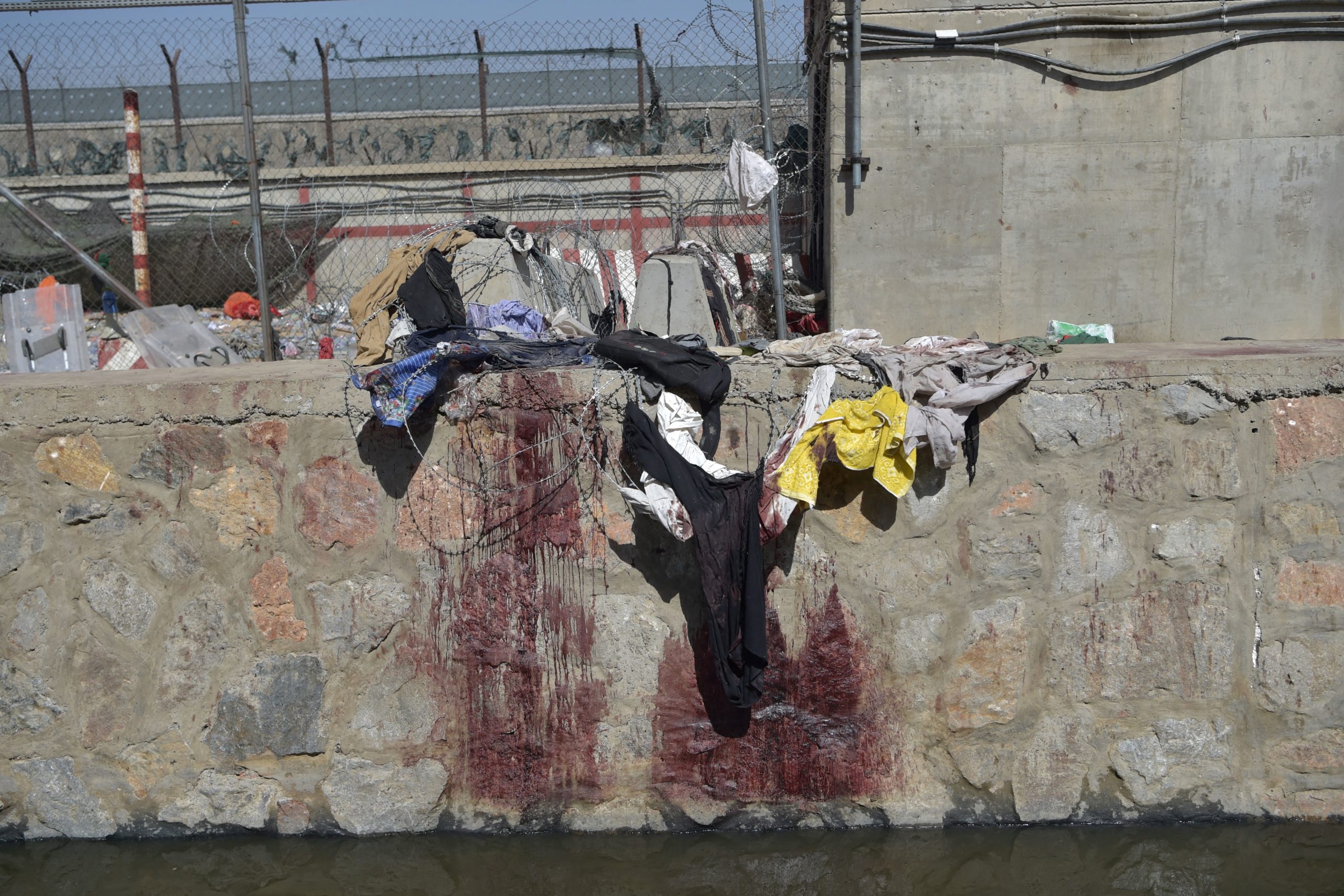 Clothes and blood stains of Afghan people who were waiting to be evacuated are seen at the site of the August 26 twin suicide bombs, which killed scores of people including 13 US troops, at Kabul airport on August 27, 2021. (Photo by WAKIL KOHSAR / AFP) (Photo by WAKIL KOHSAR/AFP via Getty Images)