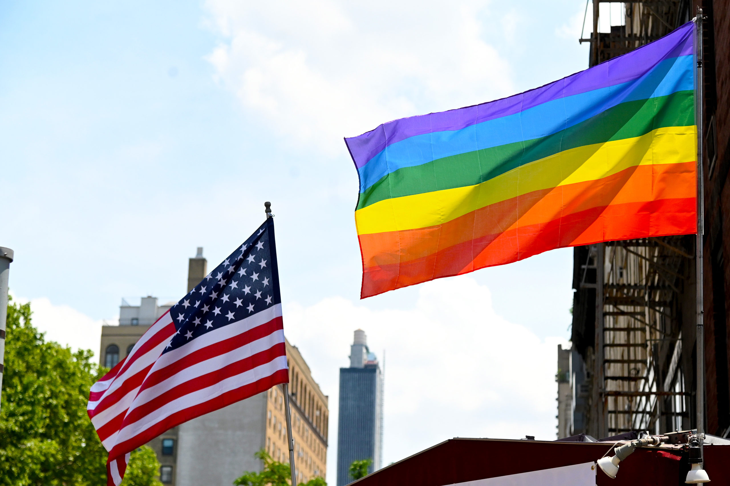 NEW YORK, NEW YORK - JUNE 20: An American Flag and Pride Flag are seen flown in Chelsea on June 20, 2020 in New York City. Due to the ongoing Coronavirus pandemic, this year's march had to be canceled over health concerns. The annual event, which sees millions of attendees, marks it's 50th anniversary since the first march following the Stonewall Inn riots. (Photo by Jamie McCarthy/Getty Images,)