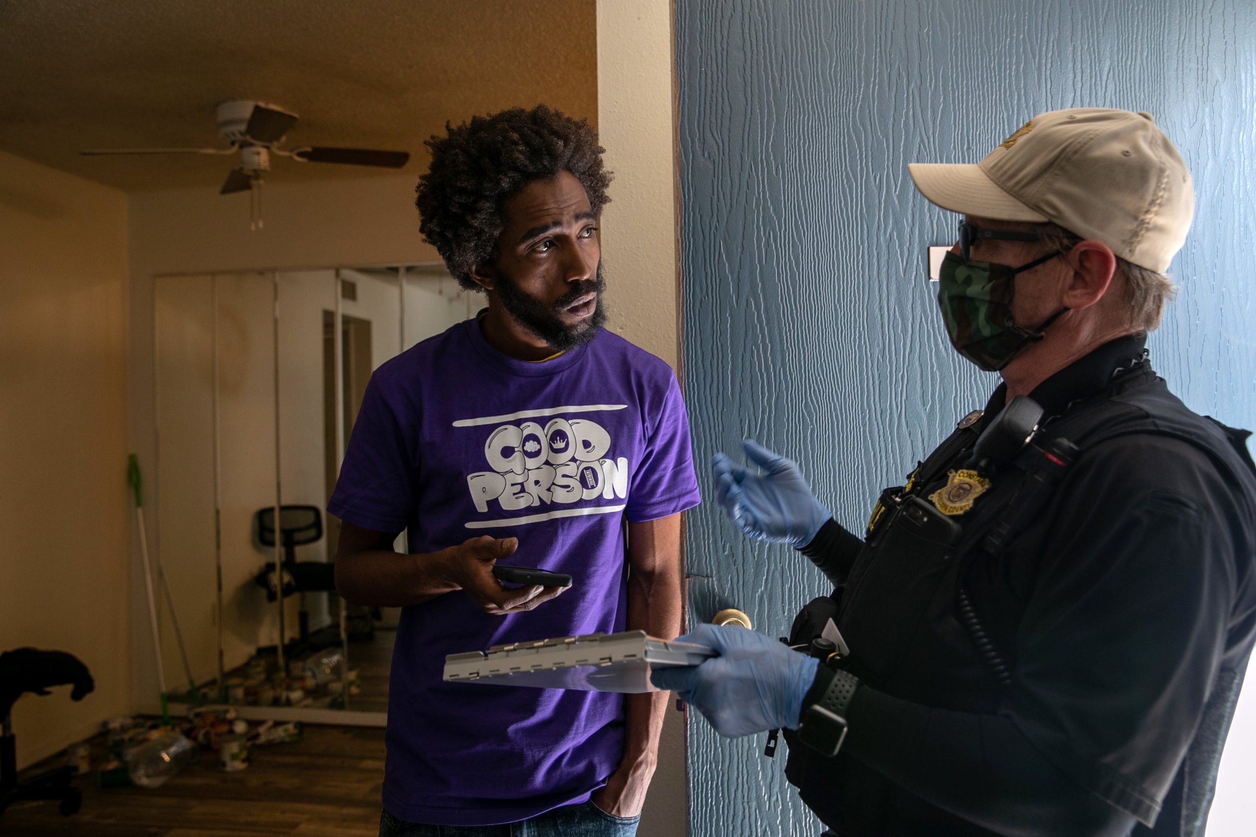 A police officer serves an eviction order to a delinquent tenant in October 2020 in Phoenix, Arizona. (John Moore/Getty Images)