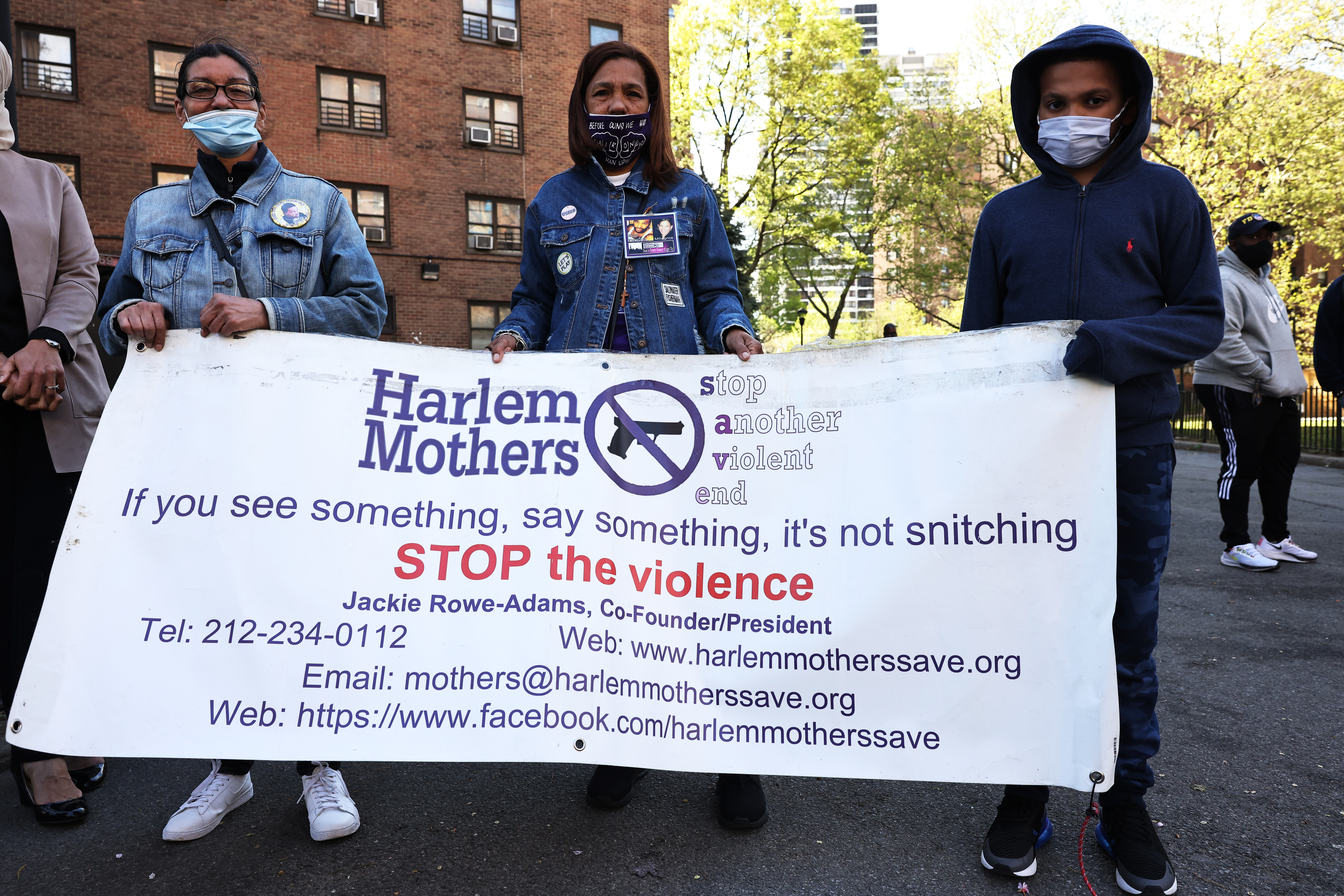NEW YORK, NEW YORK - APRIL 30: Margie Rodrigues, Milagros Ortega and Gino Myers, 10, hold a banner as they join others before a peace walk to denounce the rise of gun violence in the city in the Harlem neighborhood on April 30, 2021 in New York City. Anti-gun violence organizations, community leaders and members of the community marched through the streets of Harlem against gun violence that has spiked since 2020. Last week, Mayor de Blasio announced his “Safe Summer NYC” plan, which would place more police officers in high-crime areas along with providing 2000 summer jobs and basketball games at various locations for youths. The program will also reactivate Operation Ceasefire, which will focus on sending members of the community to cultivate relationships with gang members. (Photo by Michael M. Santiago/Getty Images)