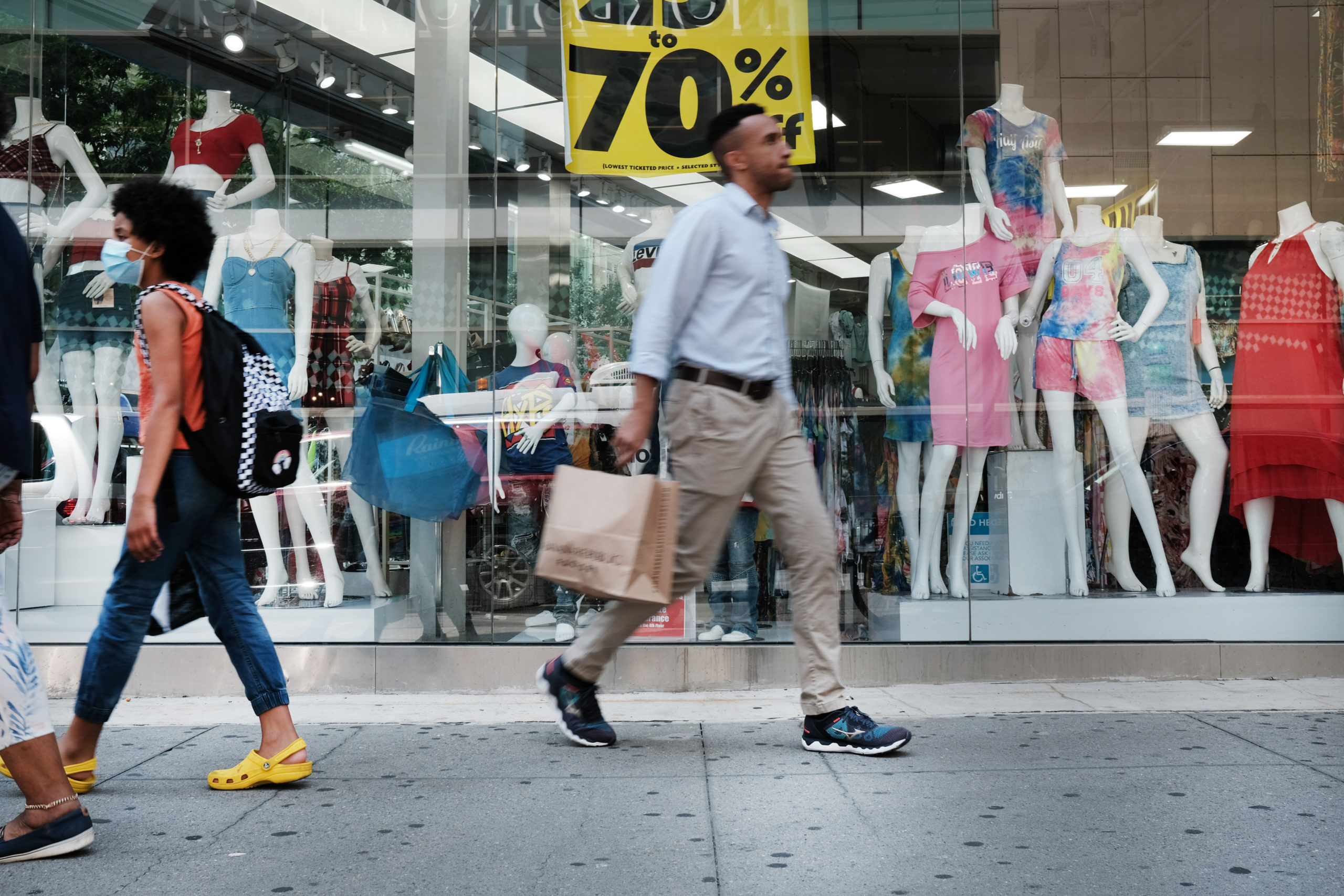 People walk through a shopping district on July 16 in New York City. (Spencer Platt/Getty Images)