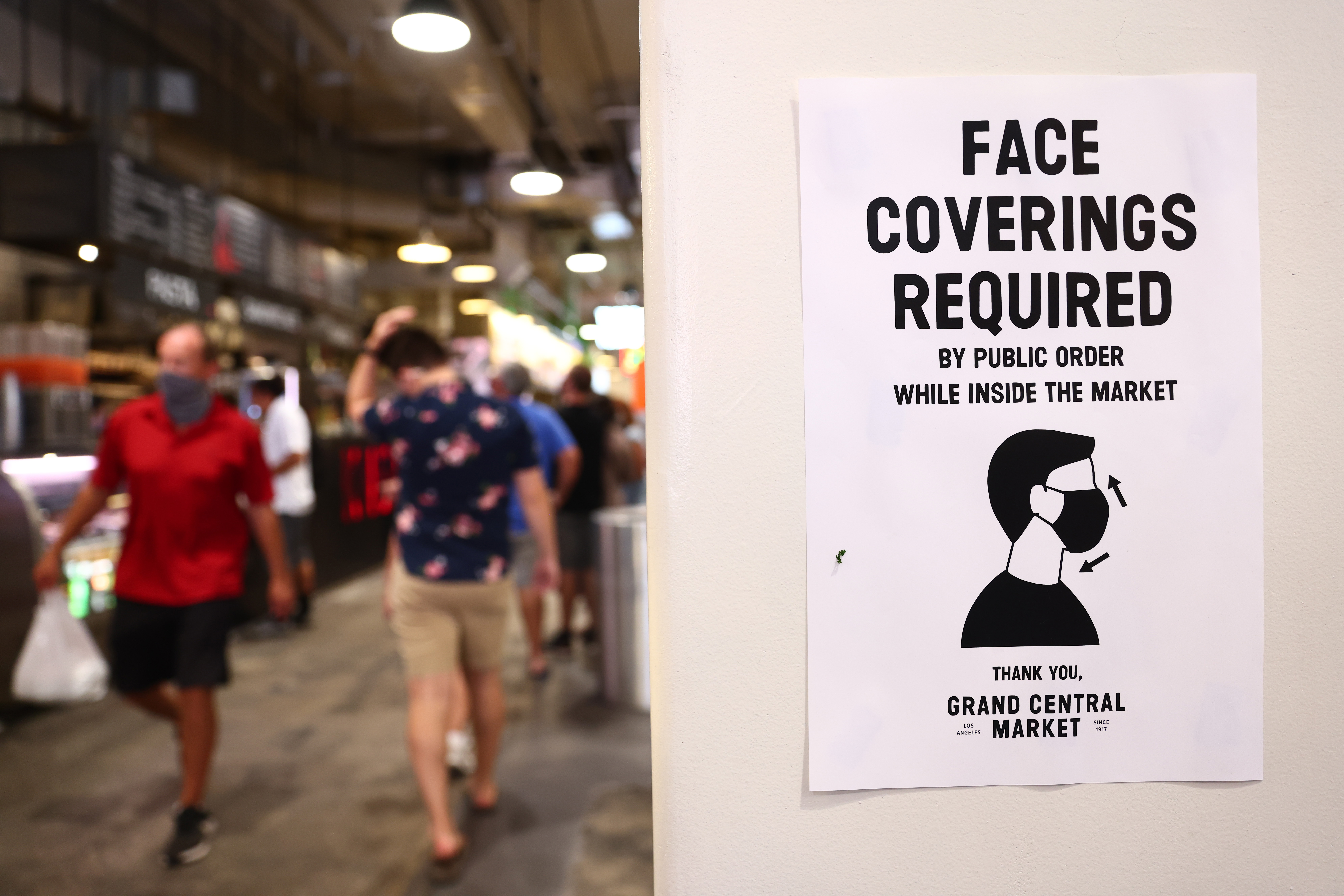 LOS ANGELES, CALIFORNIA - JULY 19: A sign is posted about required face coverings in Grand Central Market on July 19, 2021 in Los Angeles, California. A new mask mandate went into effect just before midnight on July 17th in Los Angeles County requiring all people, regardless of vaccination status, to wear a face covering in public indoor spaces amid a troubling rise in COVID-19 cases. (Photo by Mario Tama/Getty Images)