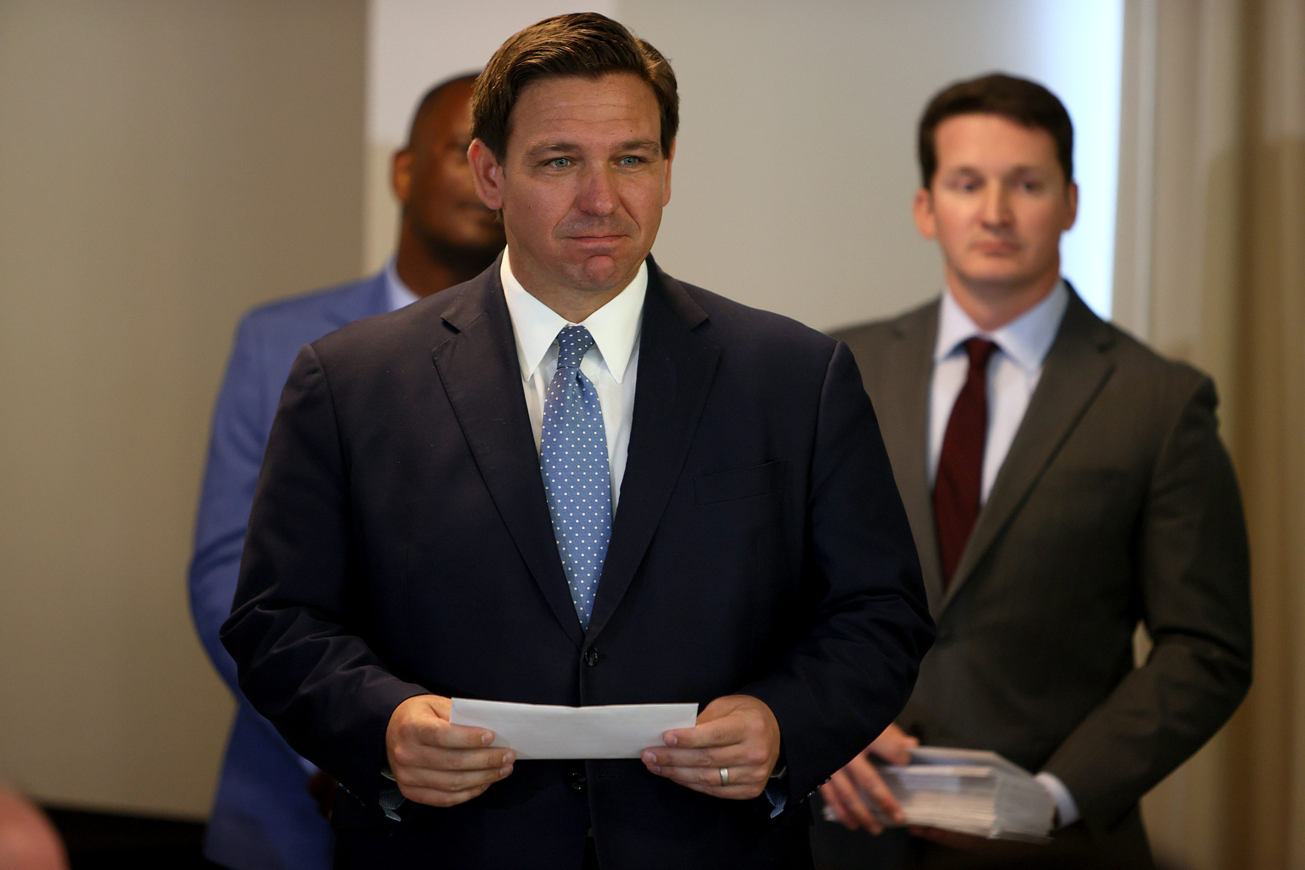 SURFSIDE, FLORIDA - AUGUST 10: Florida Gov. Ron DeSantis waits to present a check to a first responder during an event to give out bonuses to them held at the Grand Beach Hotel Surfside on August 10, 2021 in Surfside, Florida. DeSantis gave out some of the $1,000 checks that the Florida state budget passed for both first responders and teachers across the state. (Photo by Joe Raedle/Getty Images)
