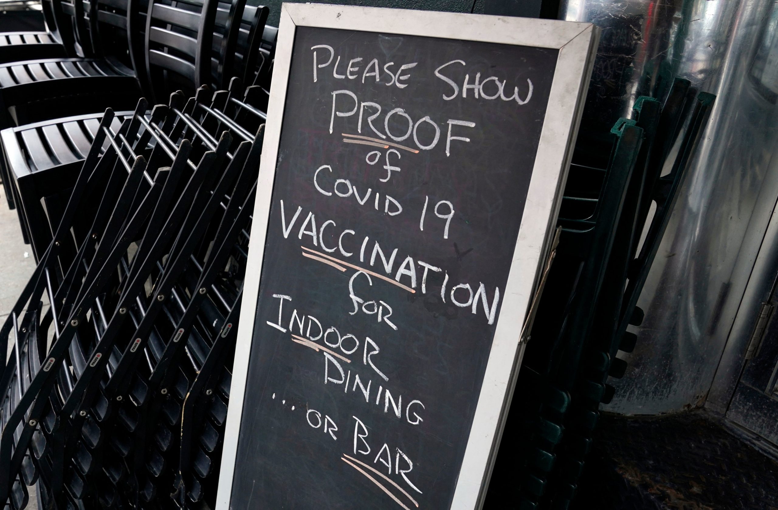 A sign is viewed at a restaurant in New York's Upper West Side on August 17, 2021, the first day where you have to show proof of having a Covid-19 vaccination to participate in indoor dining. - The vaccine mandate also includes indoor gyms, and all indoor entertainment in New York City. (Photo by TIMOTHY A. CLARY / AFP) (Photo by TIMOTHY A. CLARY/AFP via Getty Images)
