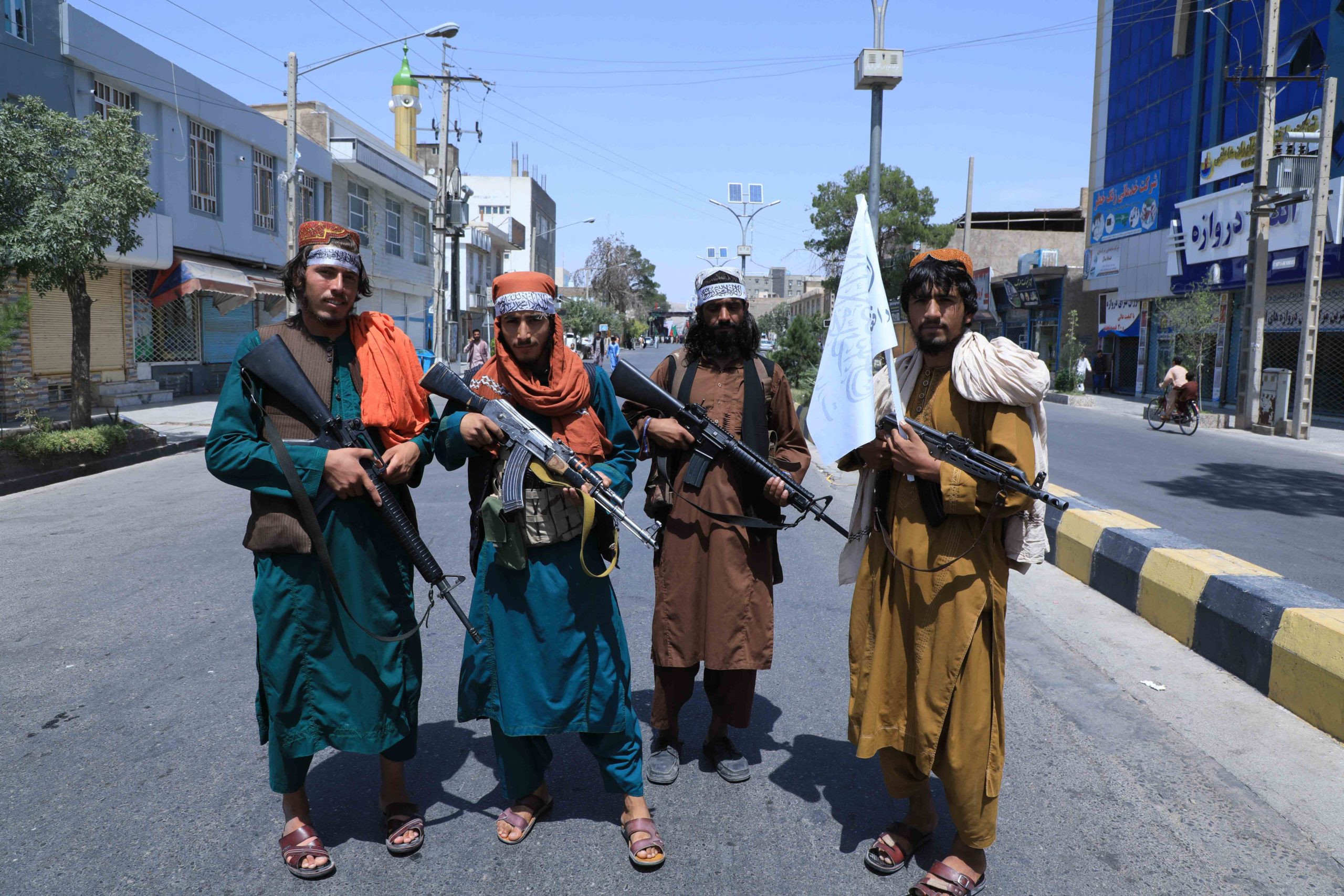 Taliban fighters stand guard along a road near the site of an Ashura procession which is held to mark the death of Imam Hussein, the grandson of Prophet Mohammad, along a road in Herat on August 19, 2021, amid the Taliban's military takeover of Afghanistan. (Photo by AREF KARIMI/AFP via Getty Images)