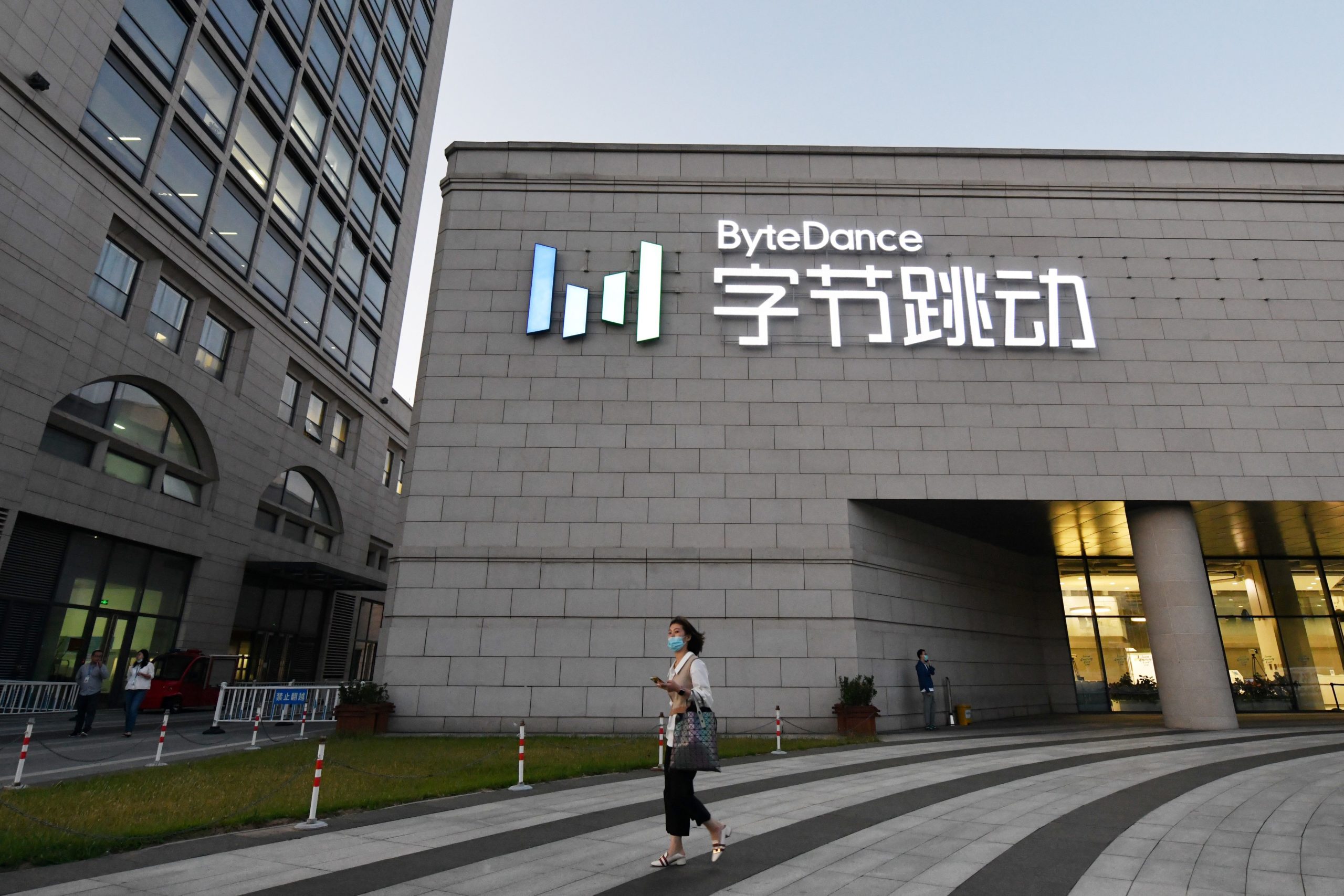 A woman walks past the headquarters of ByteDance, the parent company of video sharing app TikTok, in Beijing on September 16, 2020. (Photo by GREG BAKER/AFP via Getty Images)