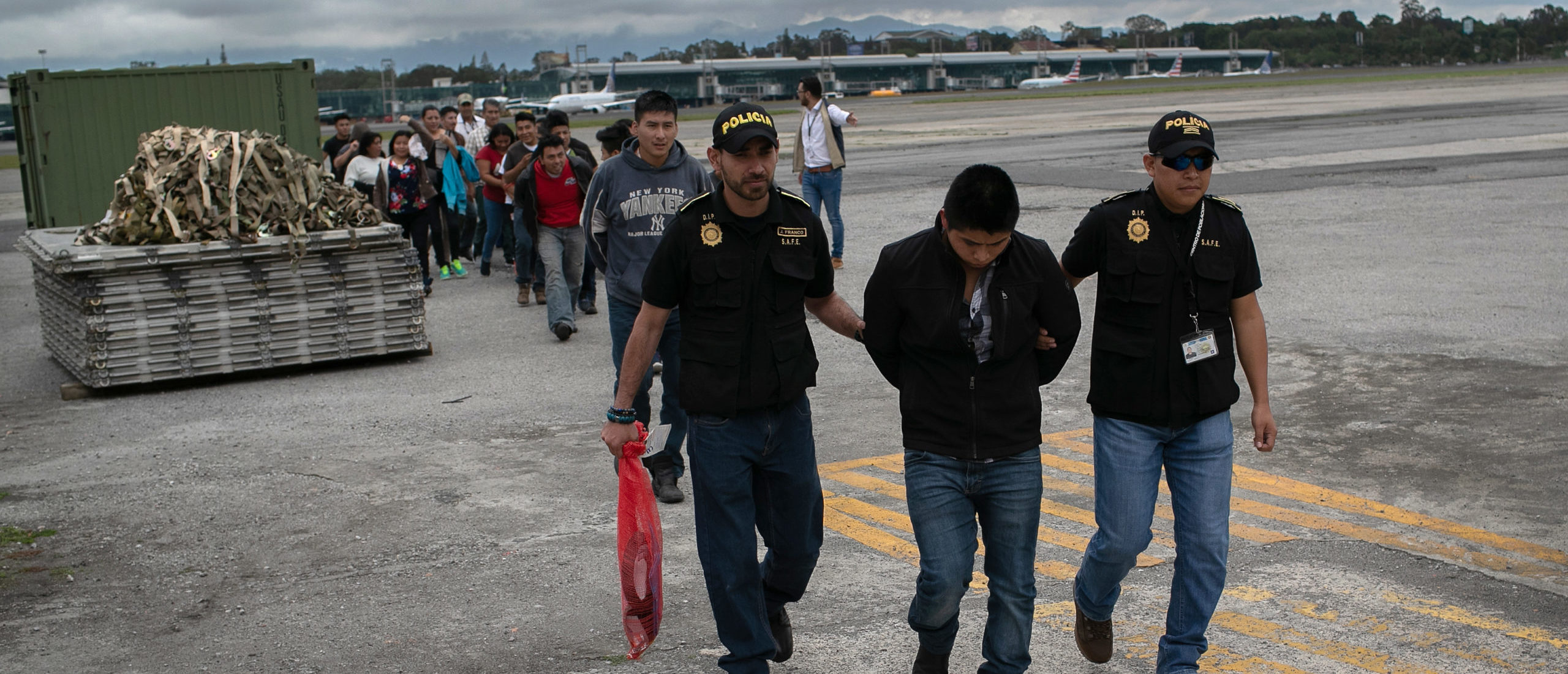 GUATEMALA CITY, GUATEMALA - MAY 30: Guatemalan police escort an accused criminal on the airport tarmac after he and other Guatemalans were deported from the United States on May 30, 2019 in Guatemala City, Guatemala. U.S. Immigration and Customs Enforcement (ICE) charters airplanes to deport some 2,000 people per week to Guatemala from various U.S. cities. (Photo by John Moore/Getty Images)