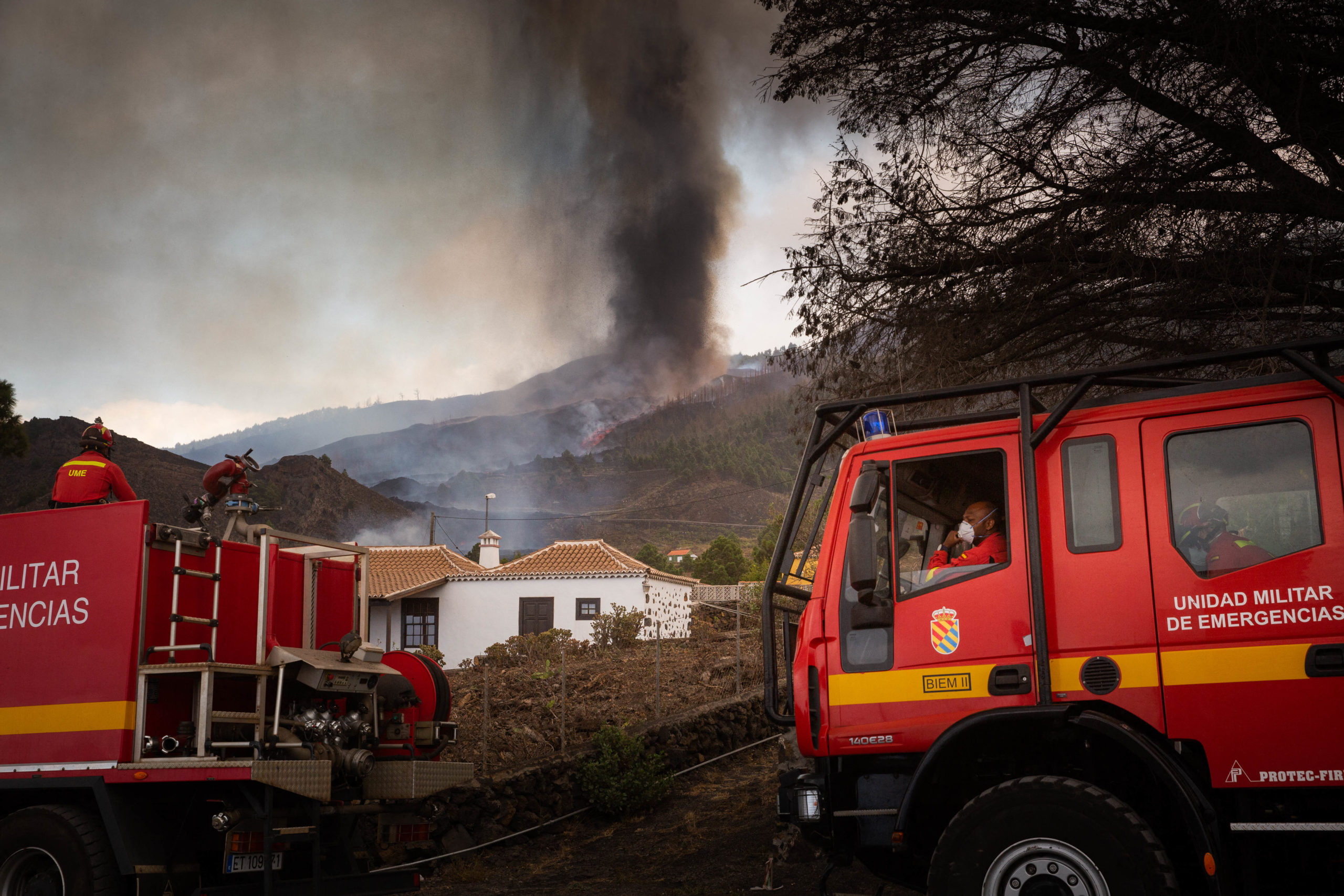 Firefighters stand next to houses in the residential area of Los Campitos at Los Llanos de Aridane, on the Canary Island of La Palma on September 20, 2021. (Photo by DESIREE MARTIN/AFP via Getty Images)