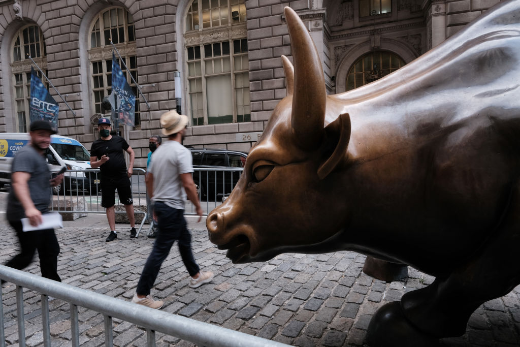 NEW YORK, NEW YORK - AUGUST 10: People walk by the Wall Street Bull near the New York Stock Exchange (NYSE) on August 10, 2021 in New York City. Markets were up in morning trading as investors look to a rare bipartisan effort in the Senate to pass a massive infrastructure bill that, if passed, will infuse billions into the American economy. (Photo by Spencer Platt/Getty Images)