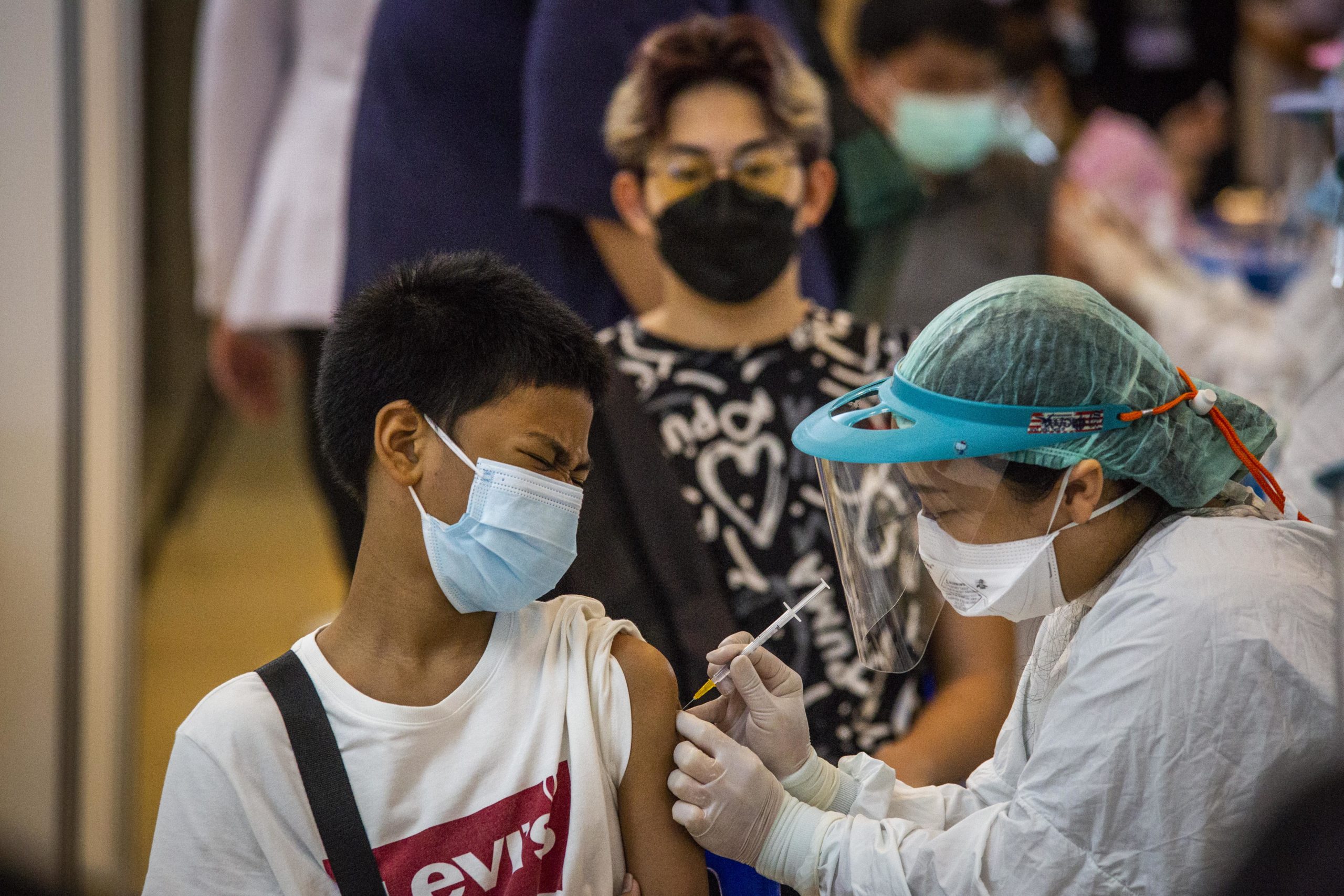 Teenagers receive their first dose of the Pfizer COVID-19 vaccine on Tuesday in Bangkok, Thailand. (Lauren DeCicca/Getty Images)