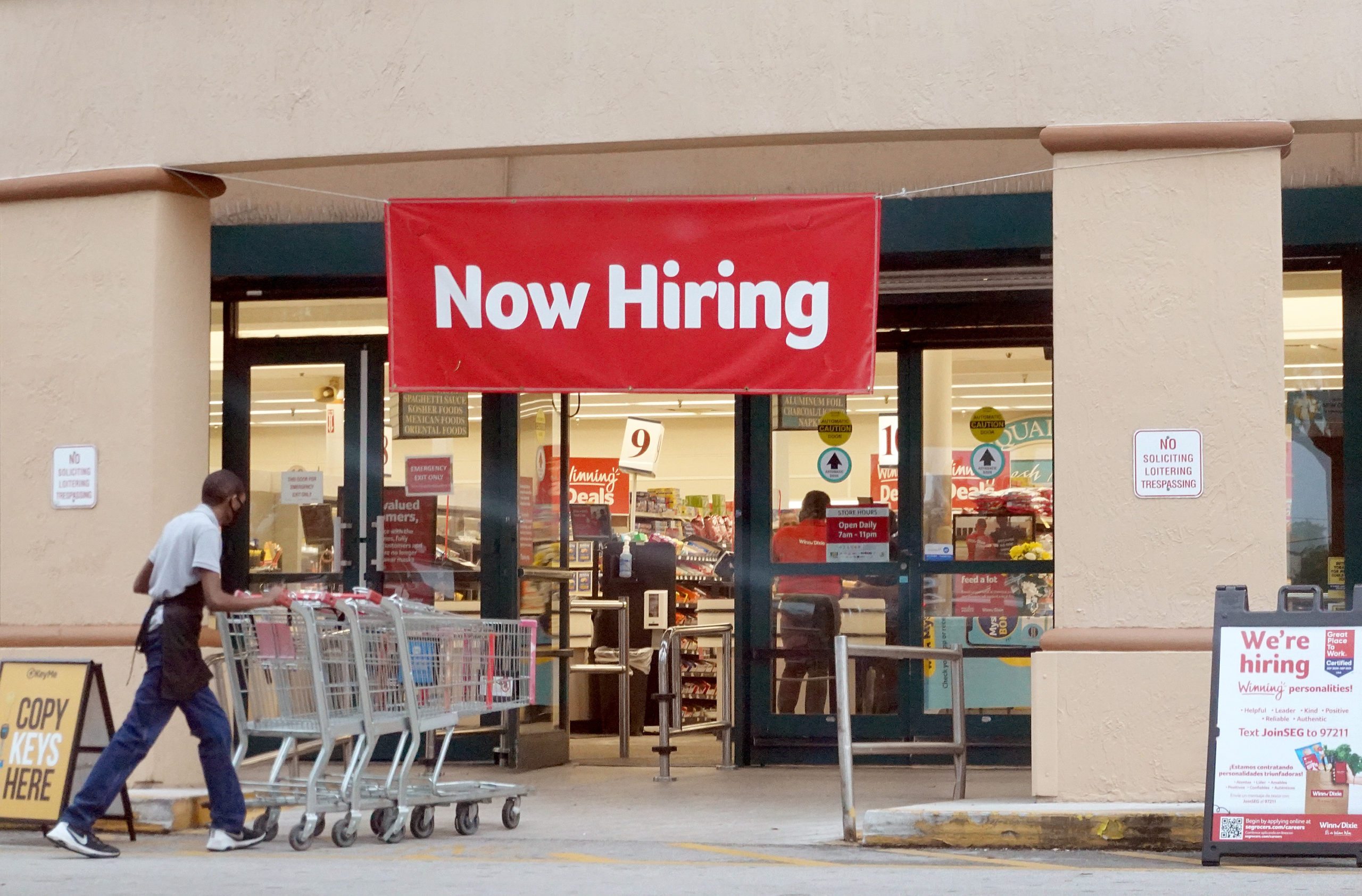 A "now hiring" sign hangs near the entrance of a Winn-Dixie Supermarket on Tuesday in Hallandale, Florida. (Joe Raedle/Getty Images)